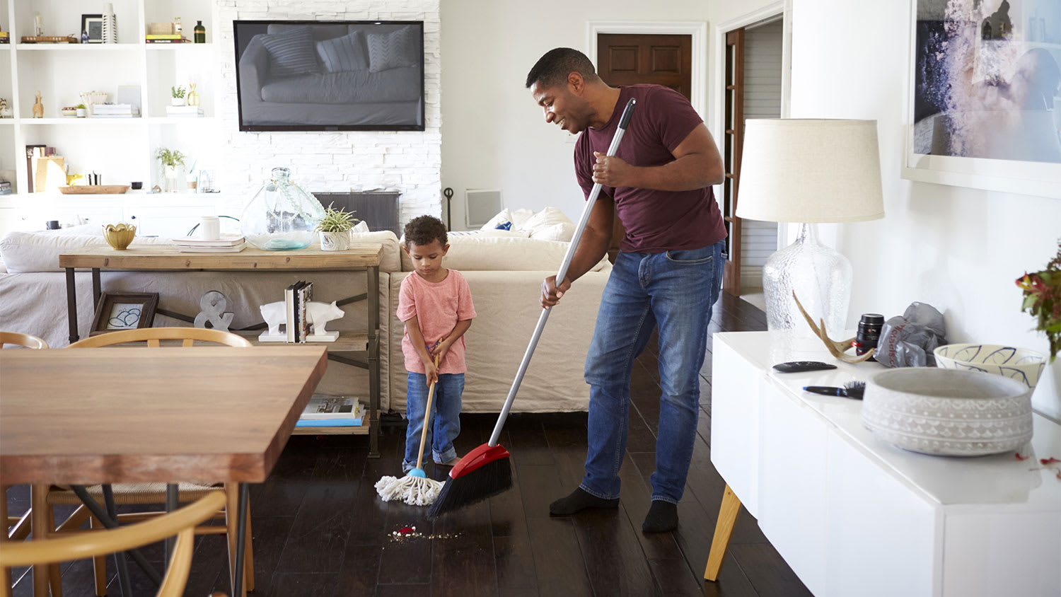 Father and son sweeping the dining room