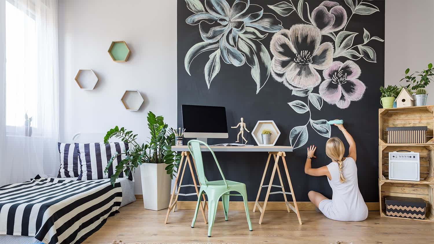 woman drawing on chalkboard wall
