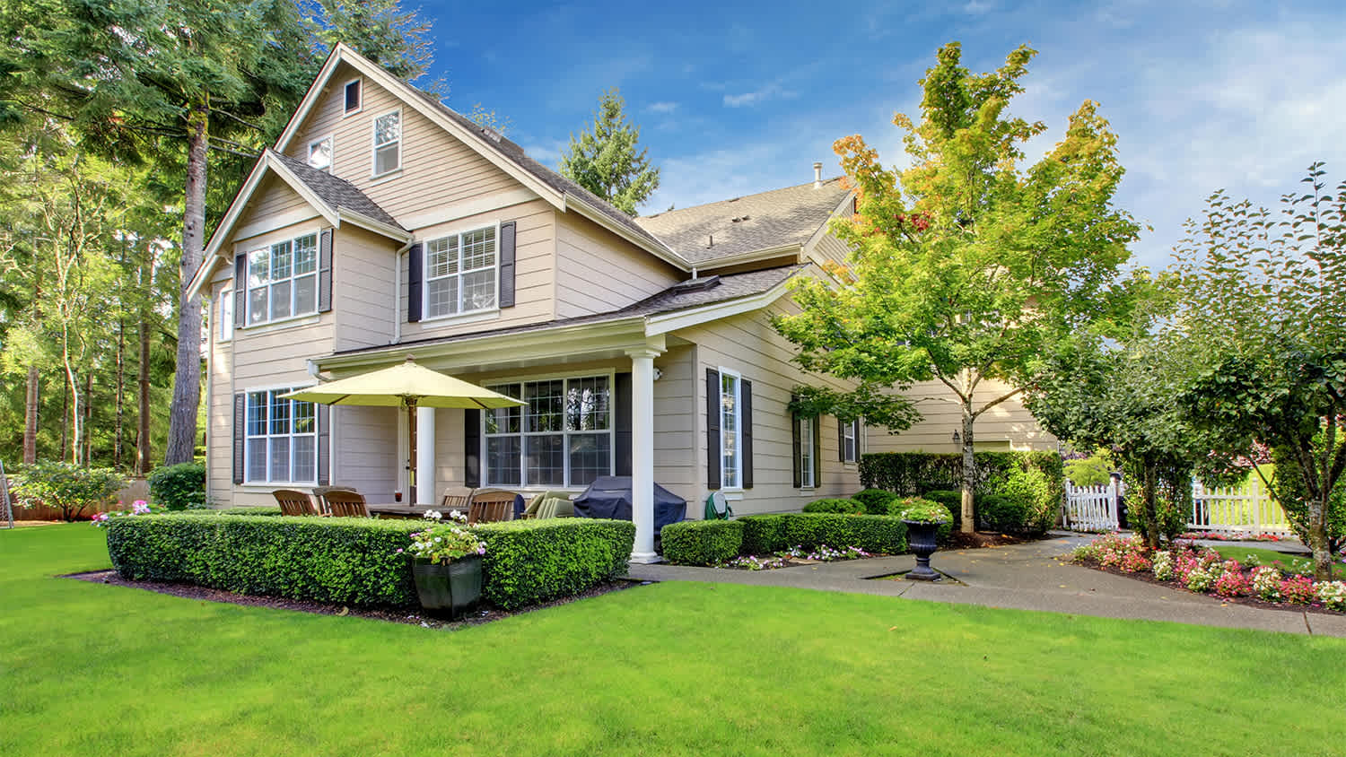 large beige house with large yard space