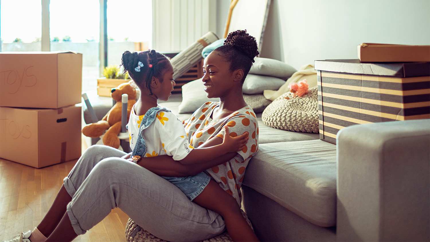 mother and daughter sitting on the floor of new house