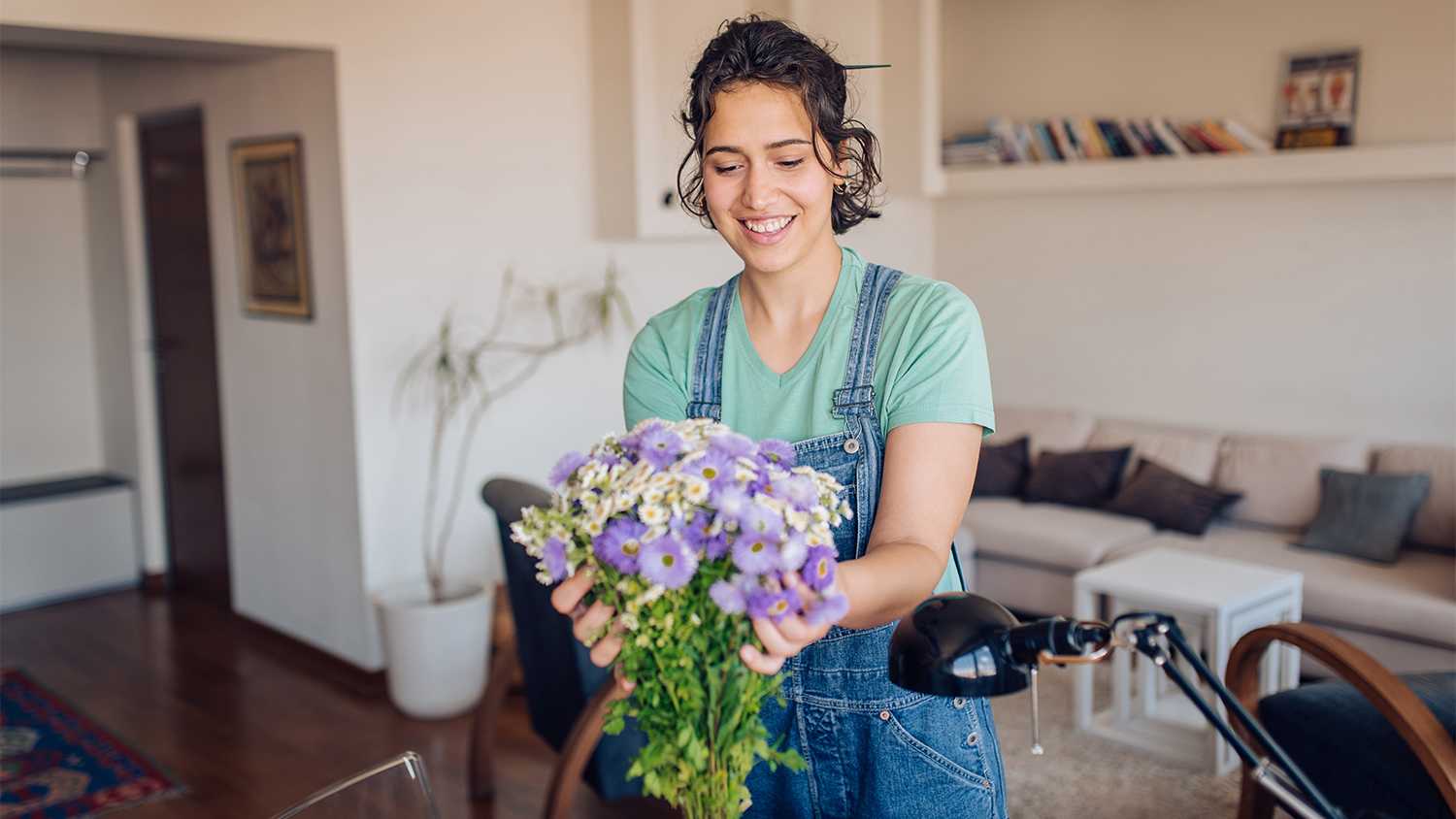 woman putting out flowers in apartment