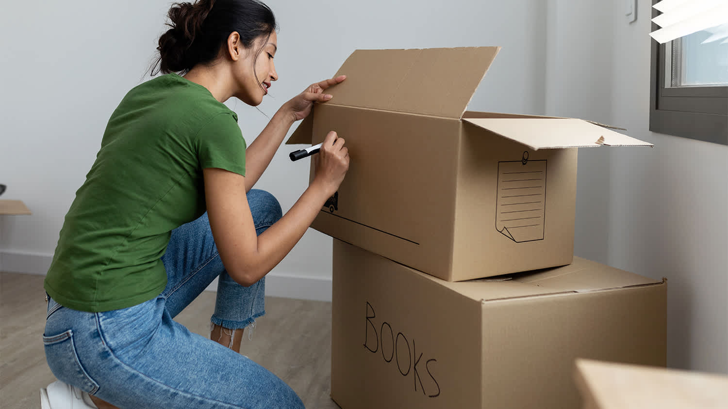 woman labeling boxes for moving