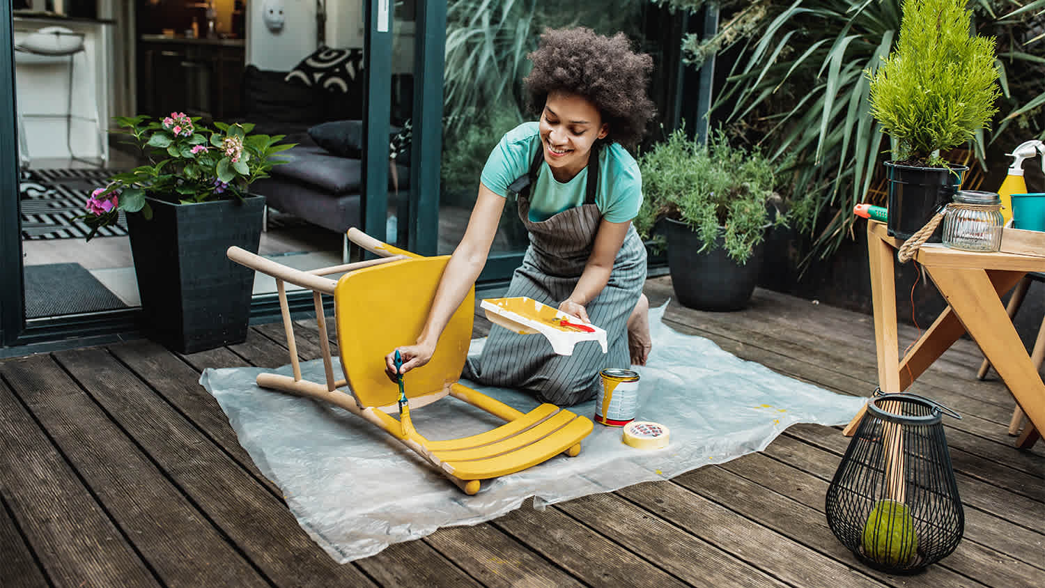 woman on the patio painting a wood chair