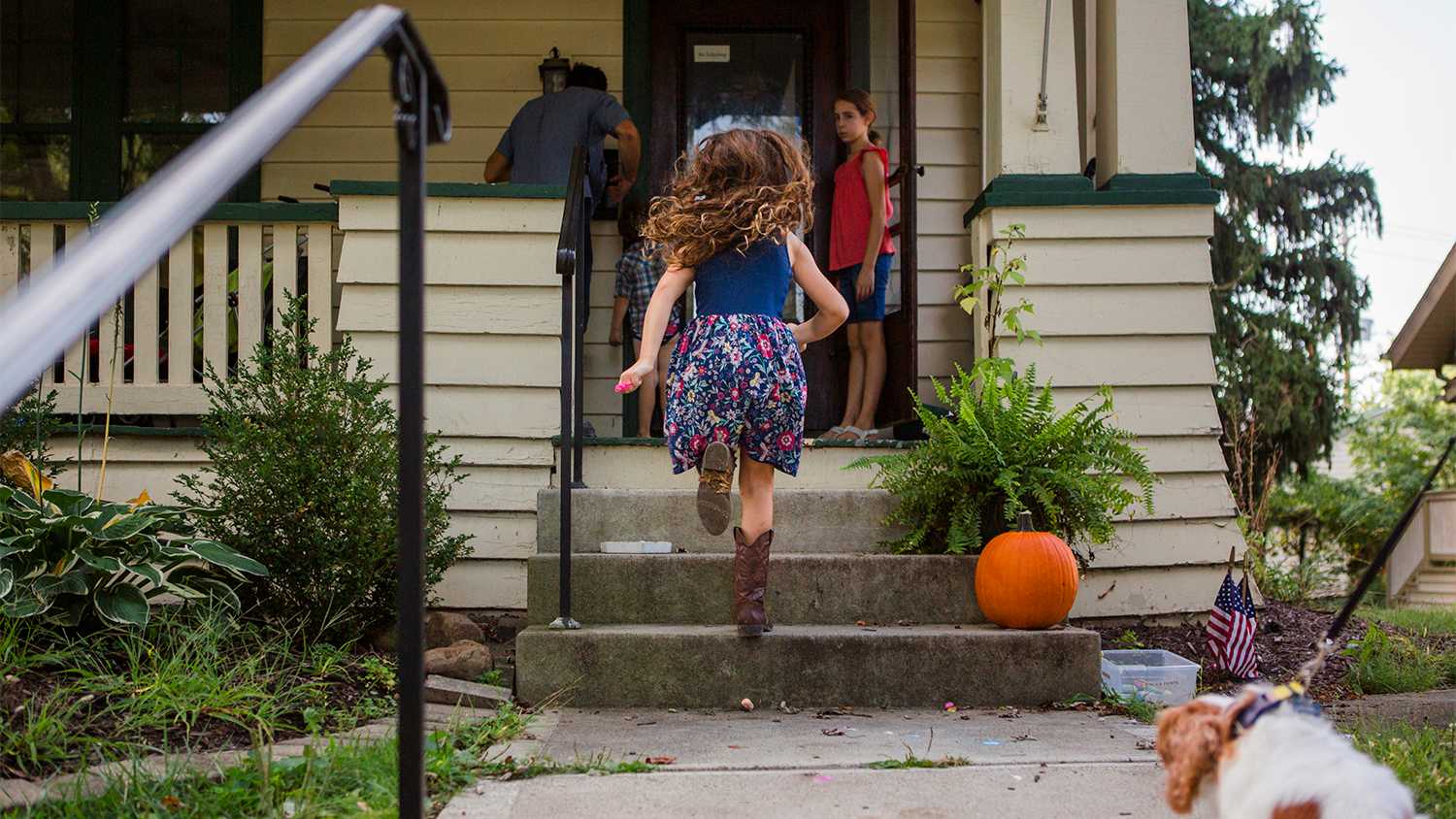 girl running up porch steps