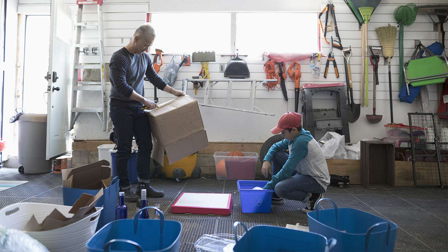 father and son spring cleaning garage