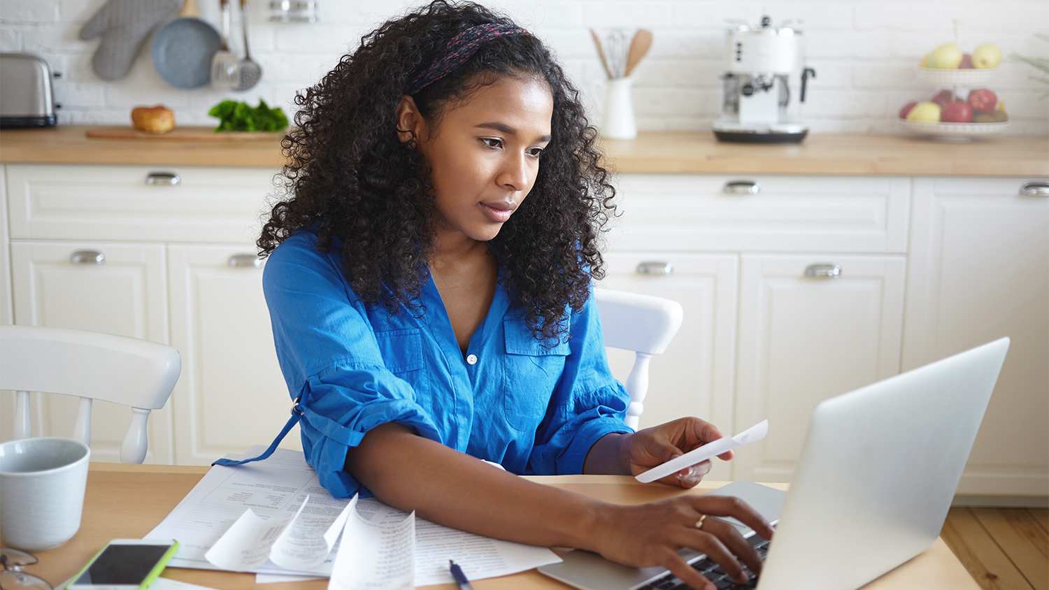 woman going over bills sitting in the kitchen
