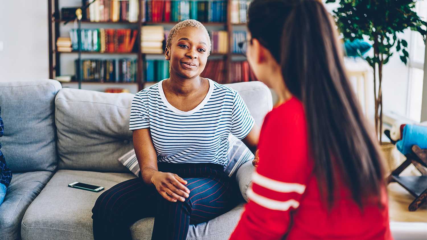 two women talking together on the couch