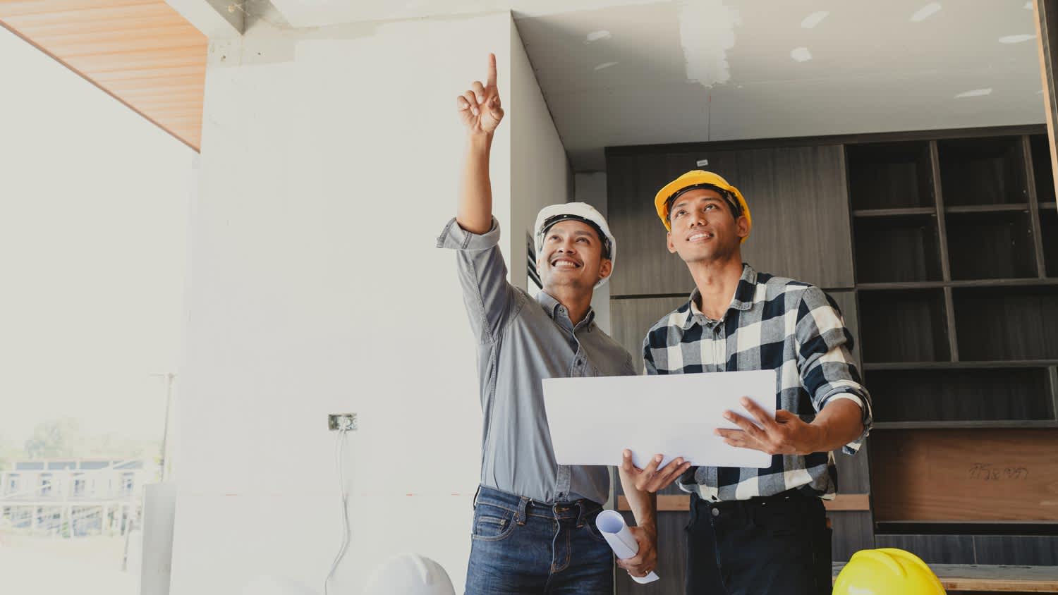 men looking at blueprints of home