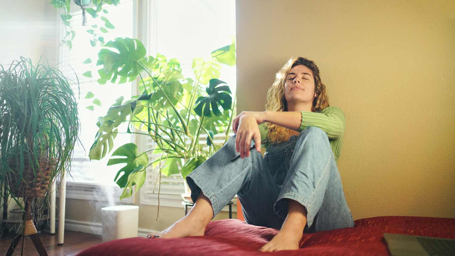 woman relaxing at home with plants and humidifier
