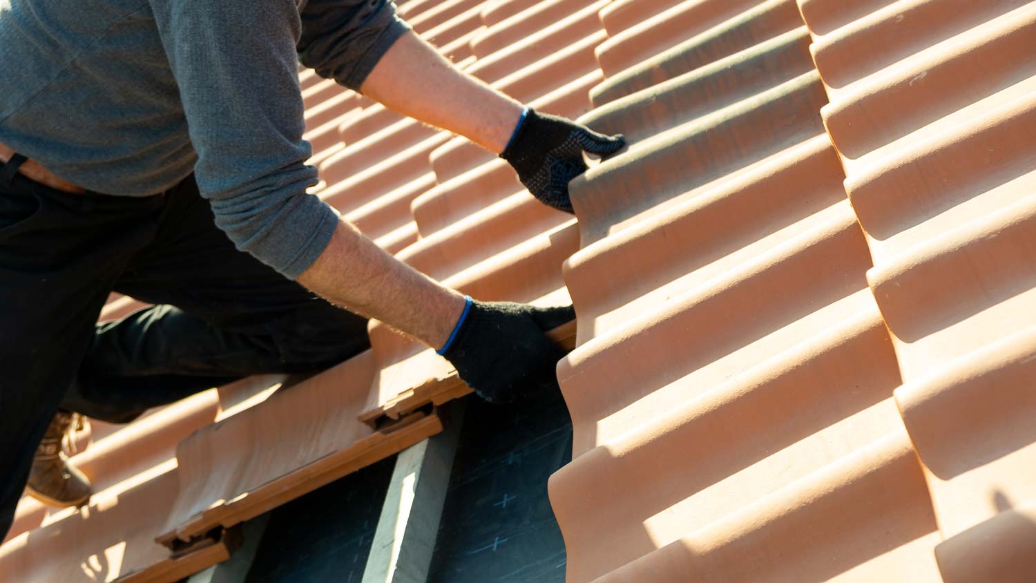 worker installing new roof tiles