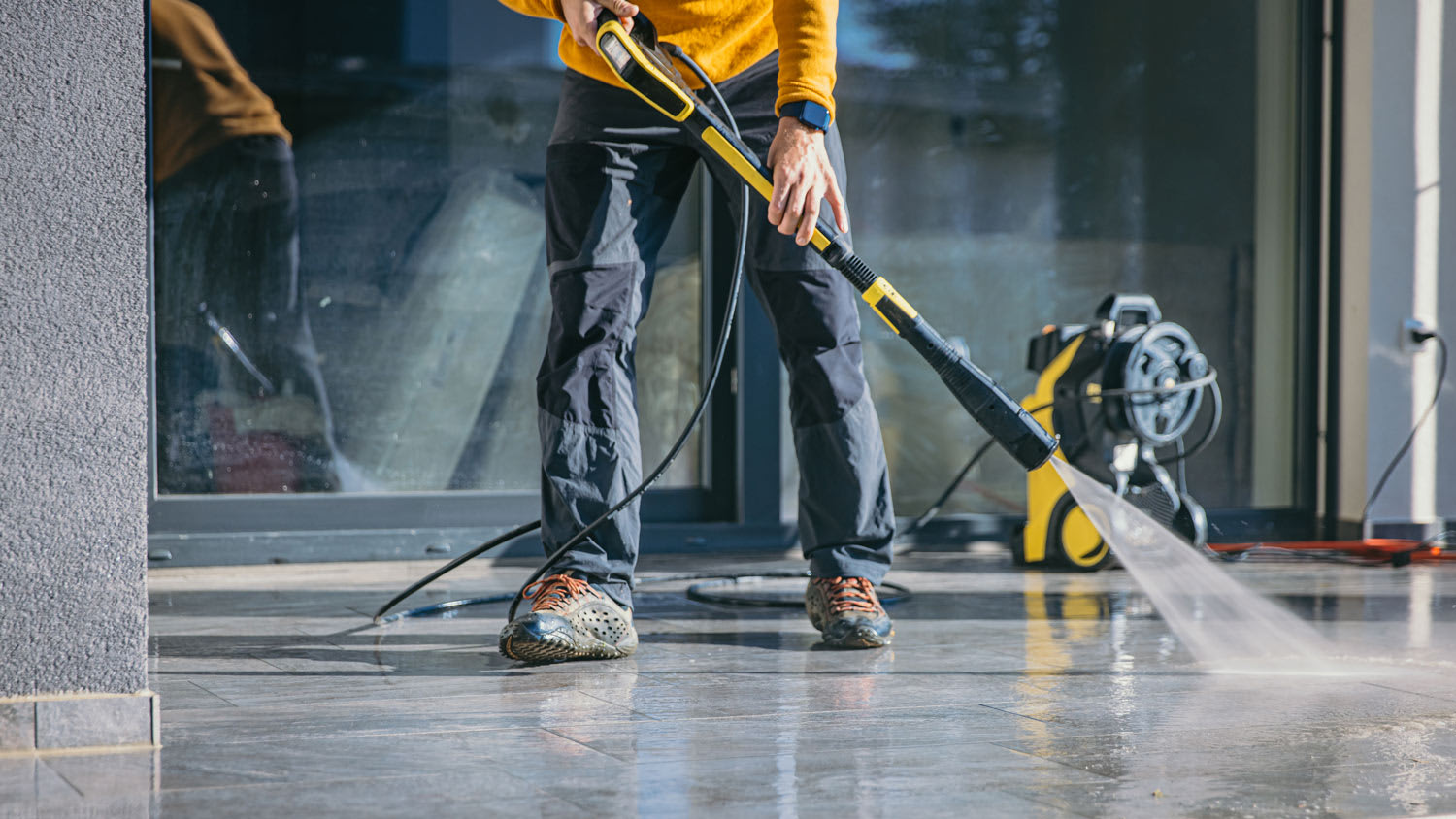 Man cleaning the terrace with high pressure cleaner