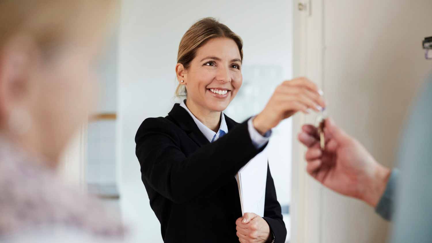 Real estate agent giving house keys to couple