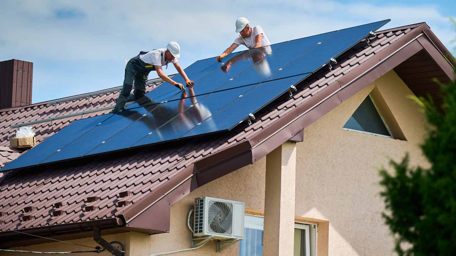 men installing solar panels on roof