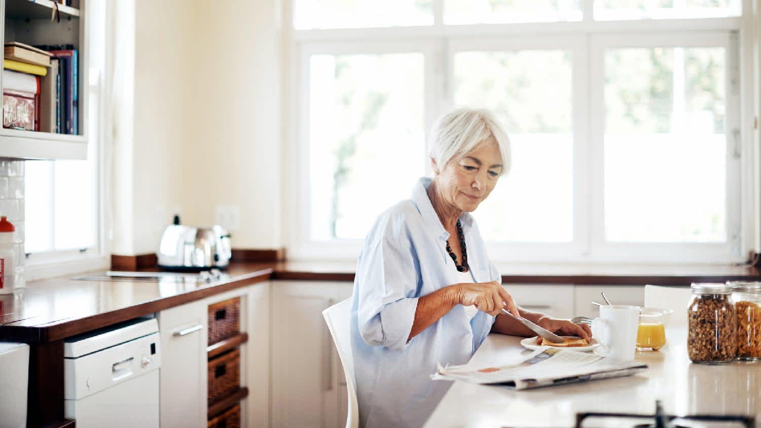 A senior woman having her breakfast in the kitchen