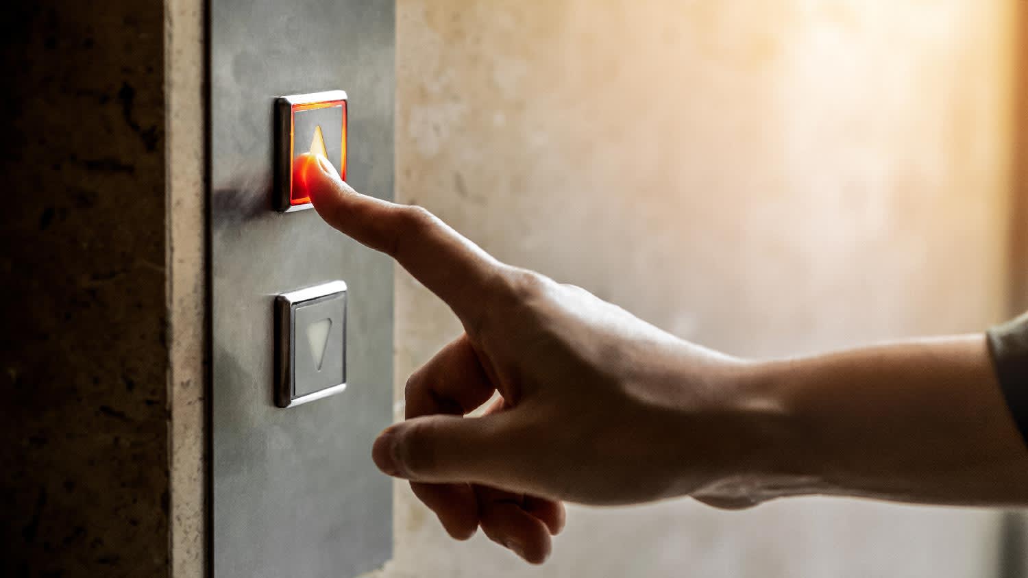 A woman pressing the elevator button