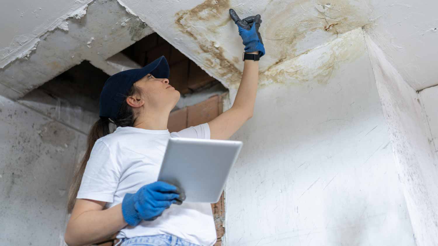 Woman checking damage ceiling