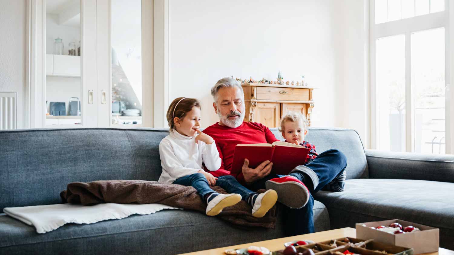 Two young grandchildren sitting with grandpa