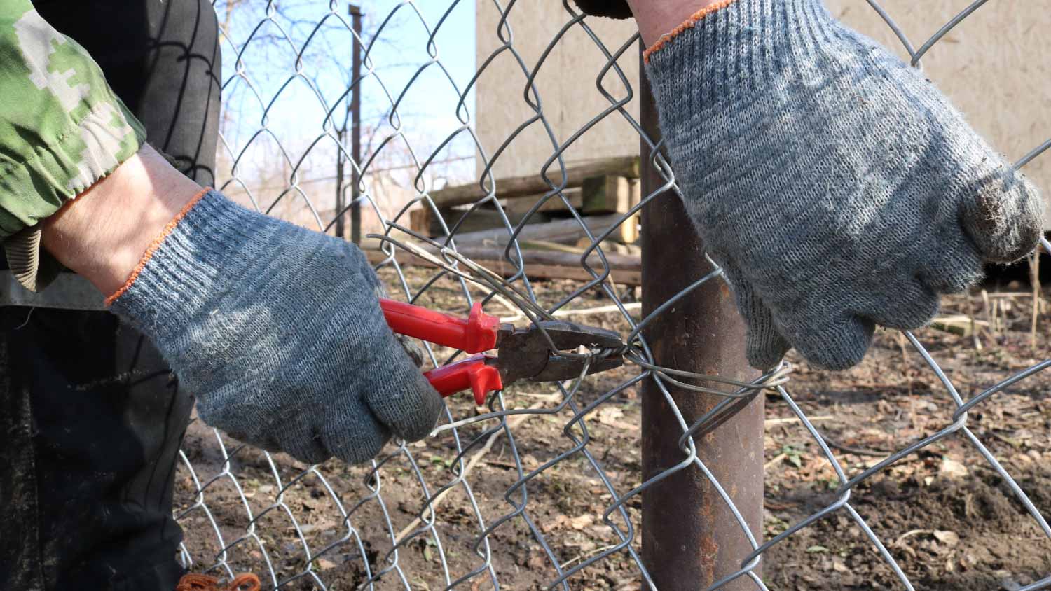 Man installing a mesh fence