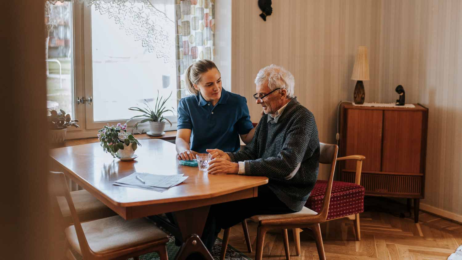 Care assistant talking to senior man