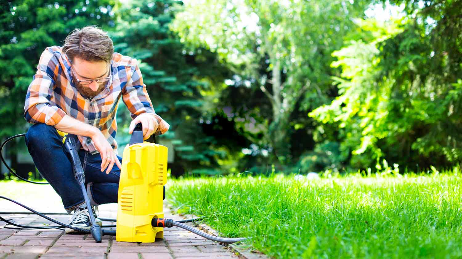 man inspecting pressure washer