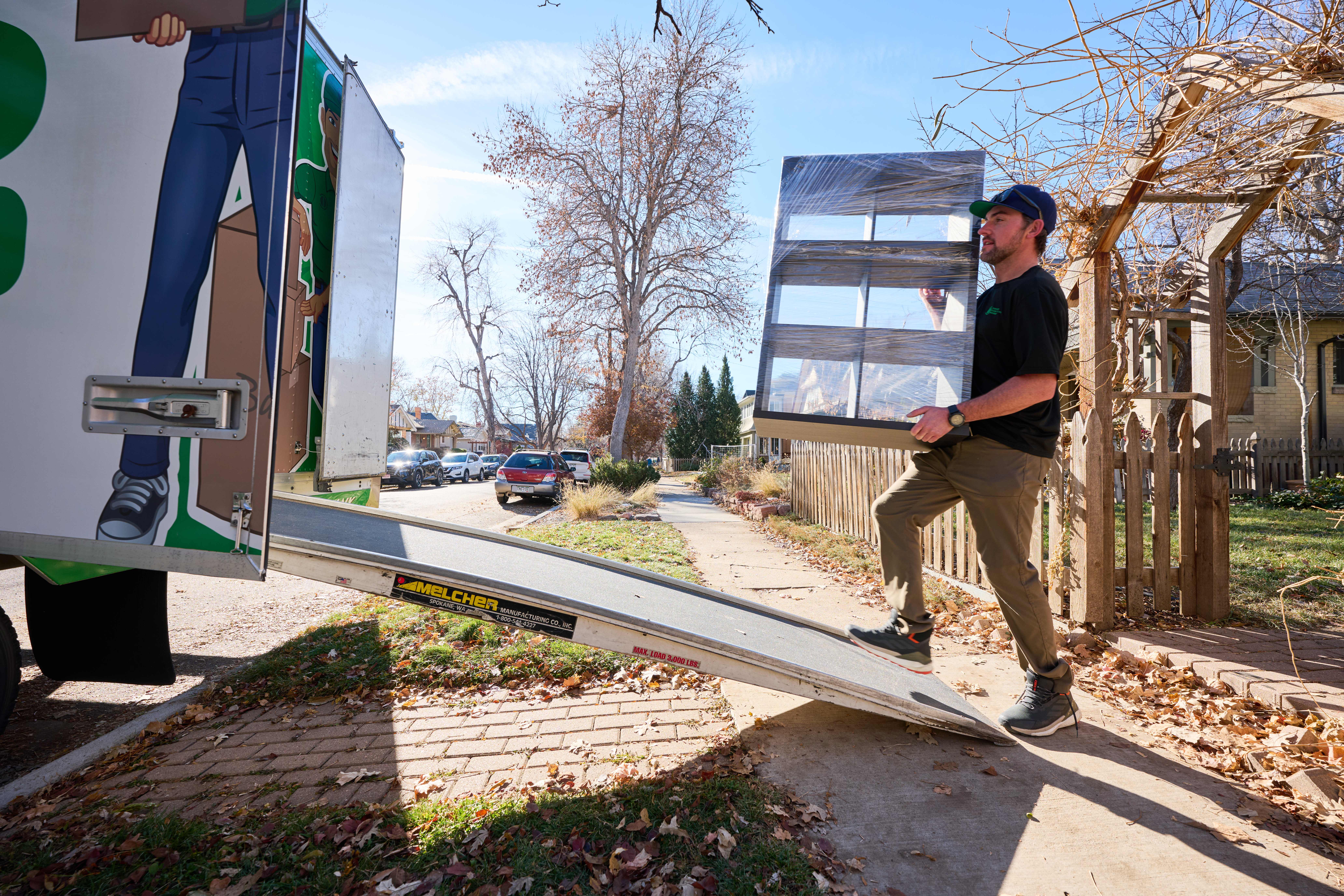 Man carrying furniture onto a moving truck.