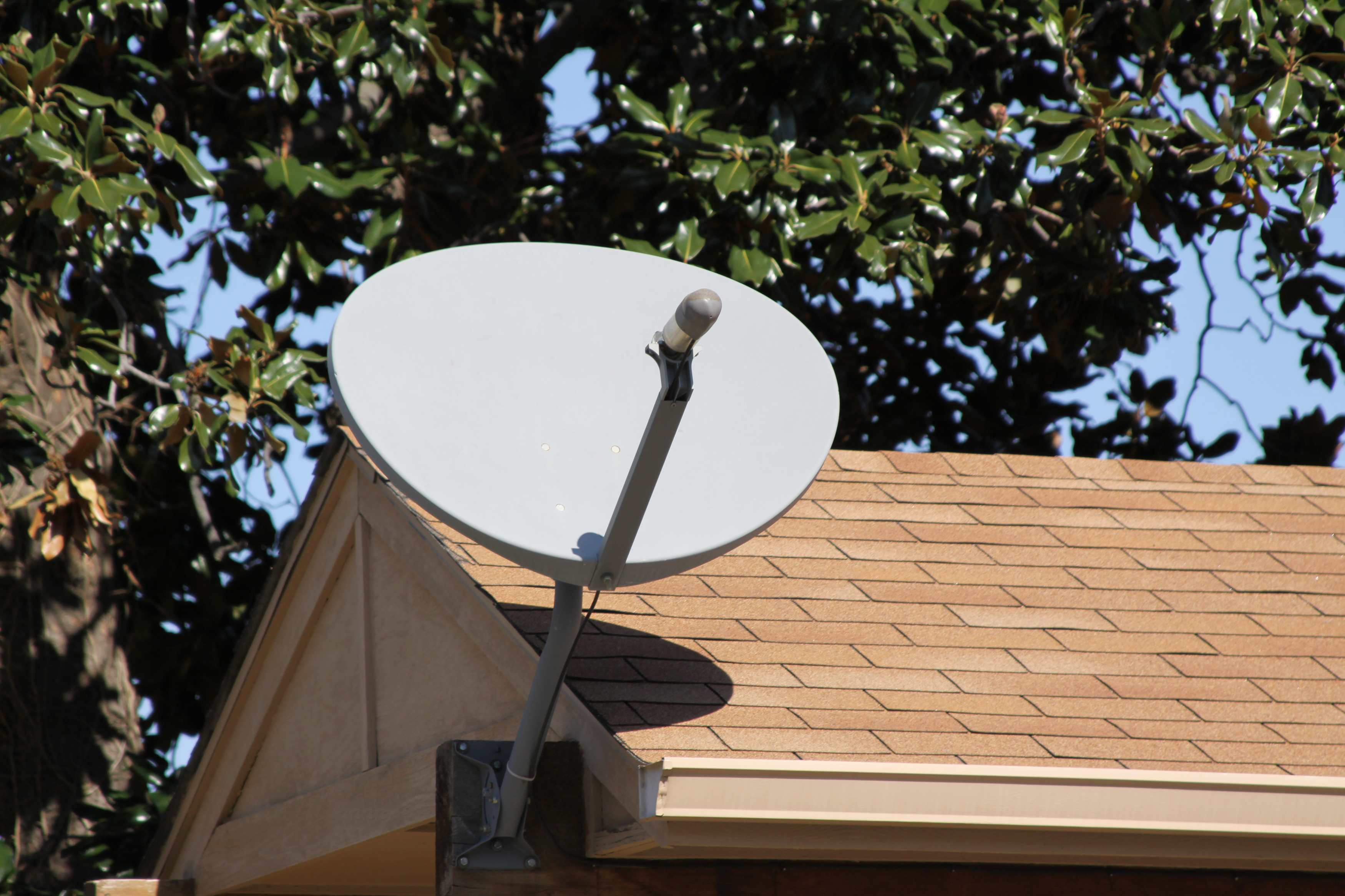 A satellite dish antenna on a rooftop is being installed or replaced for improved signal reception and connectivity