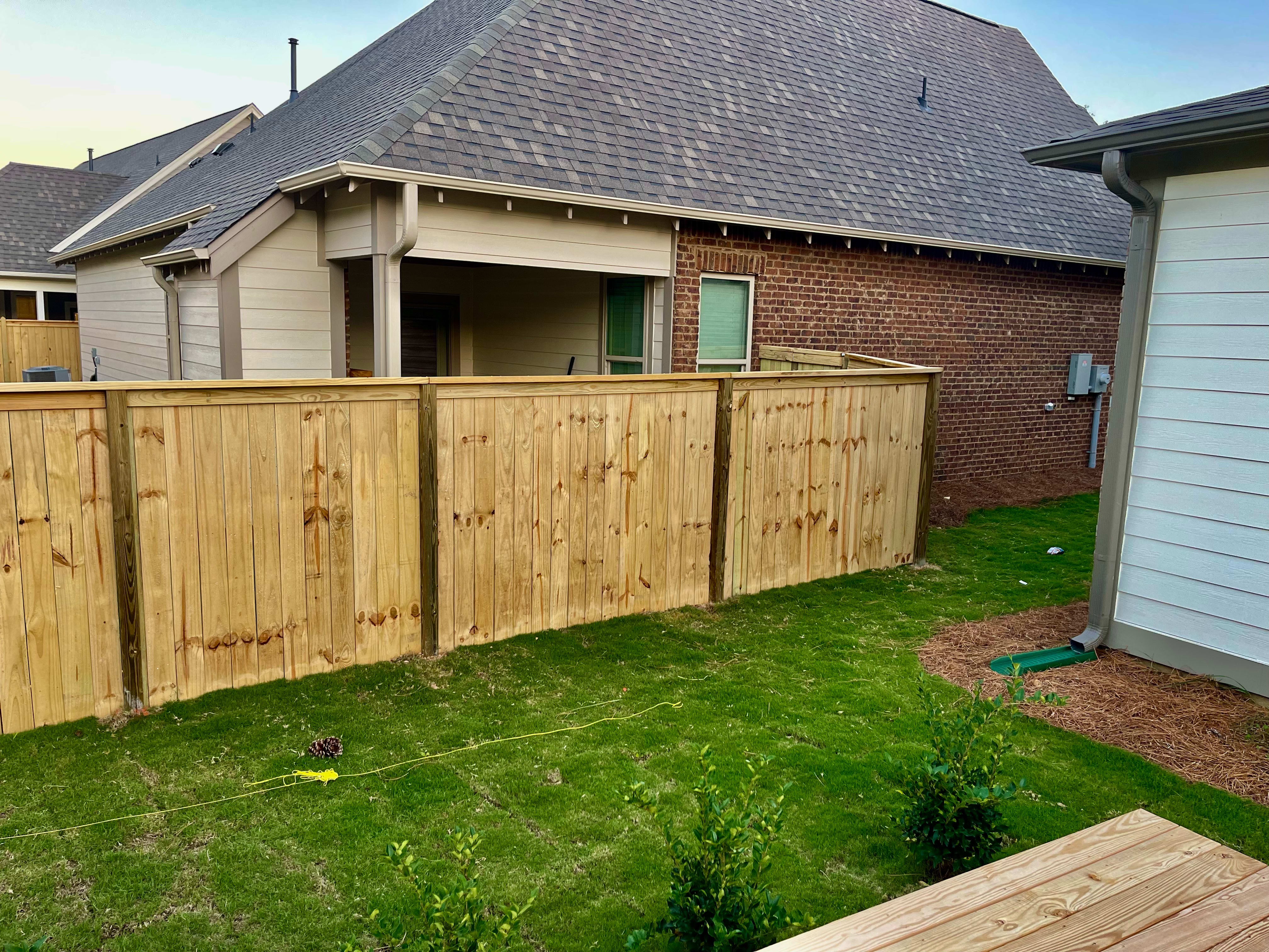 Wooden fence in corner of yard.
