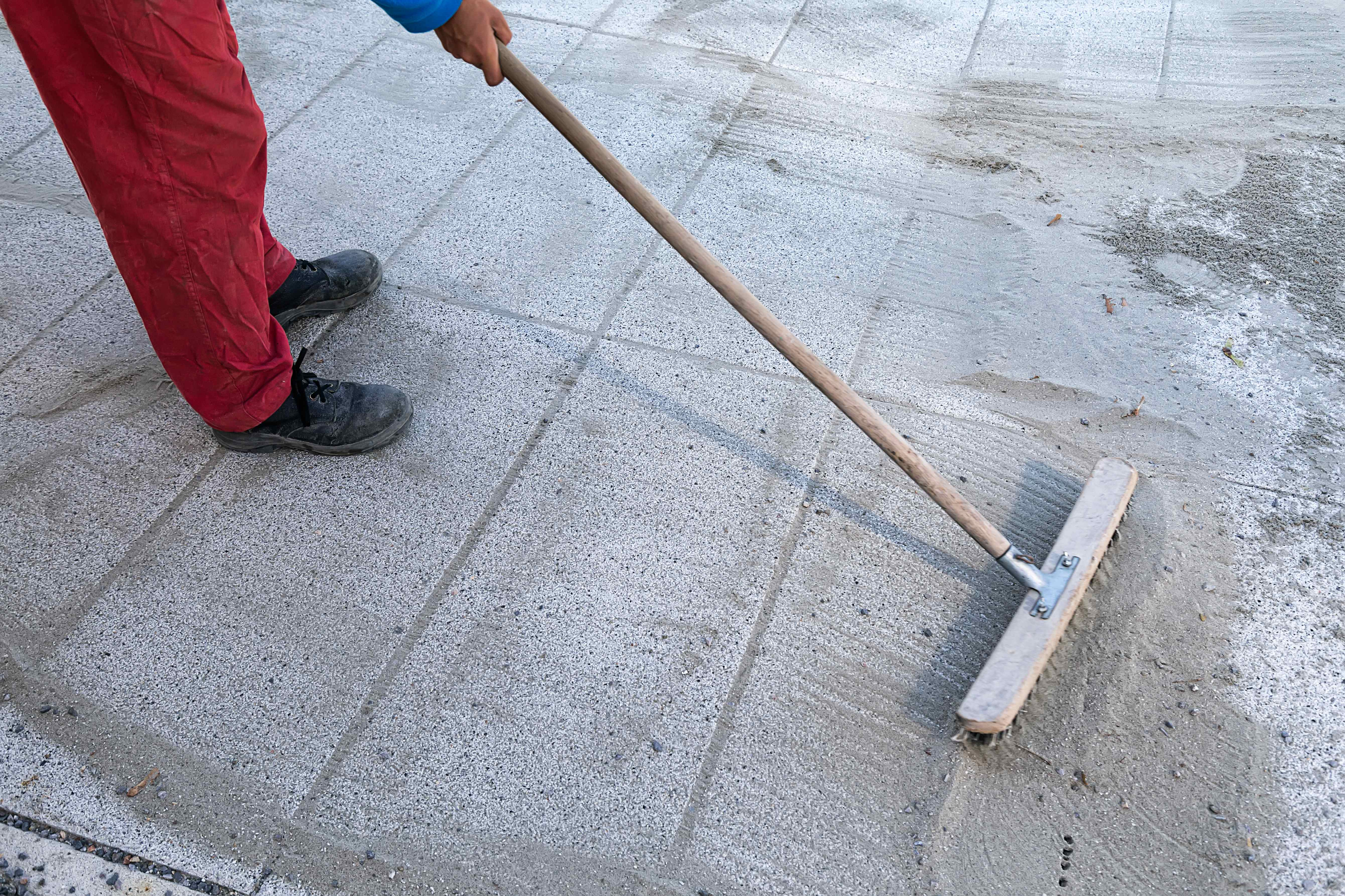 Worker installing polymeric sand