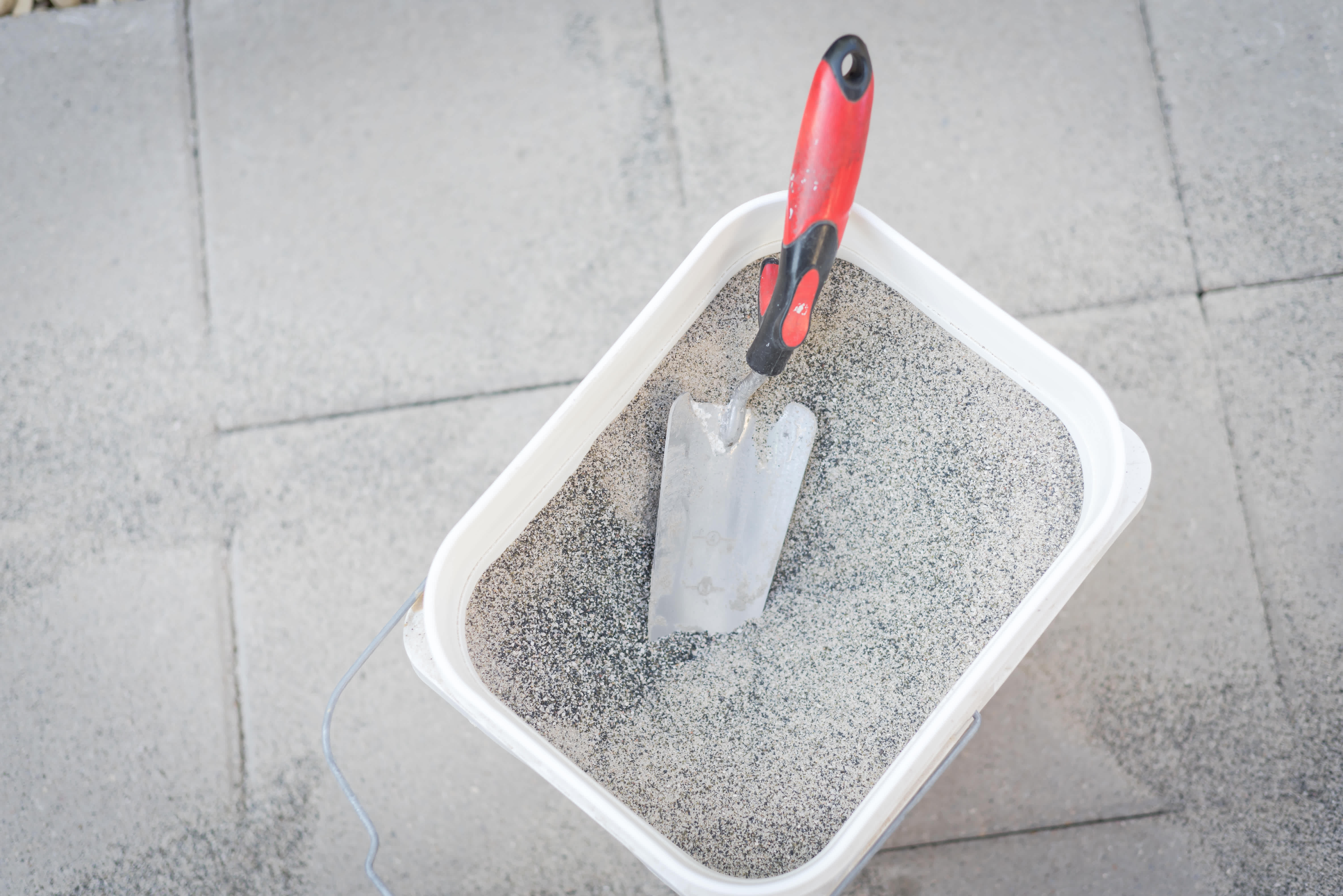 Bucket of polymeric paver sand