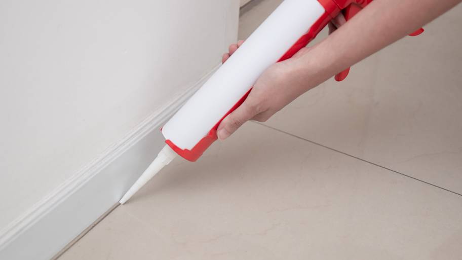 Worker using manual caulking gun