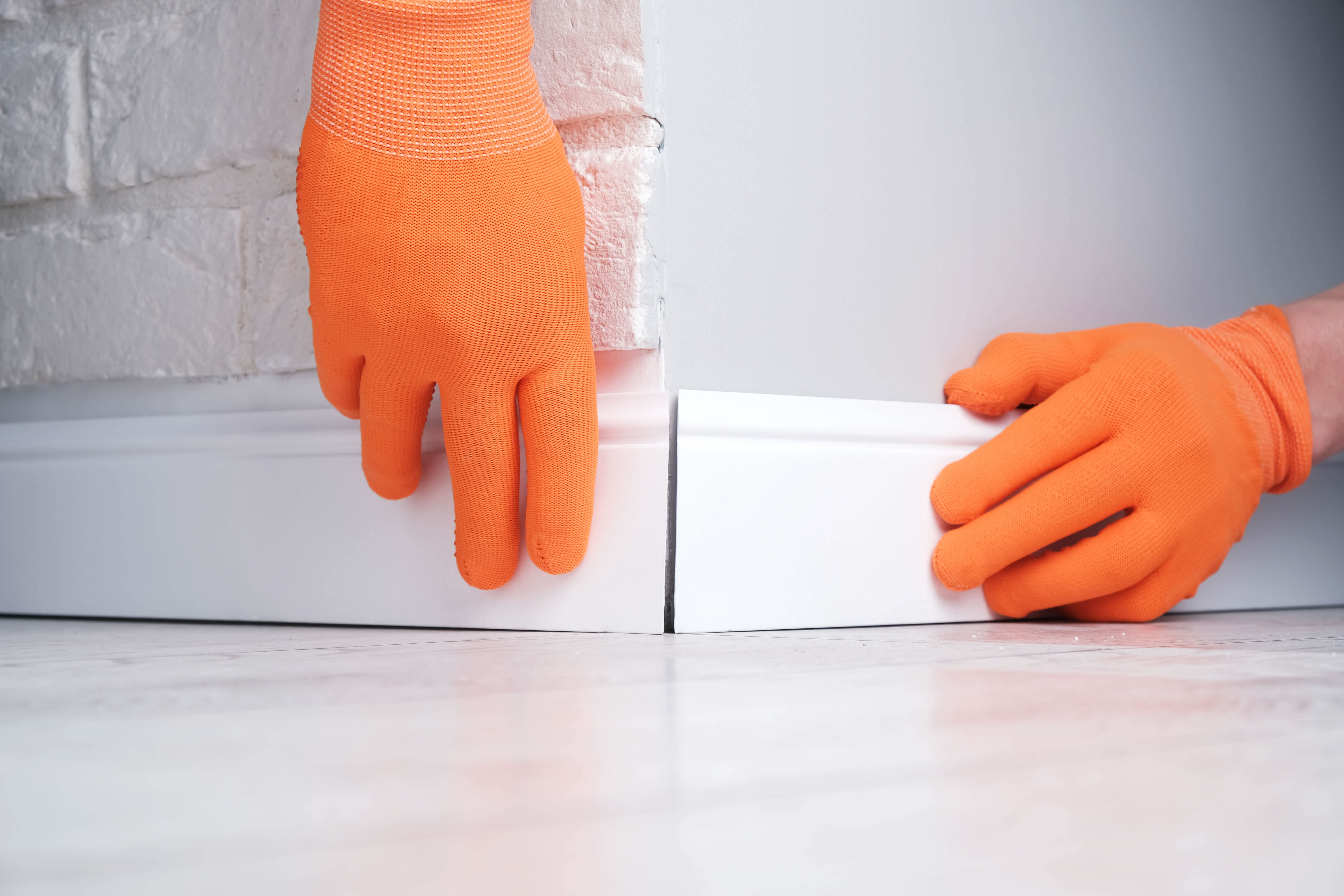 Worker installing baseboards