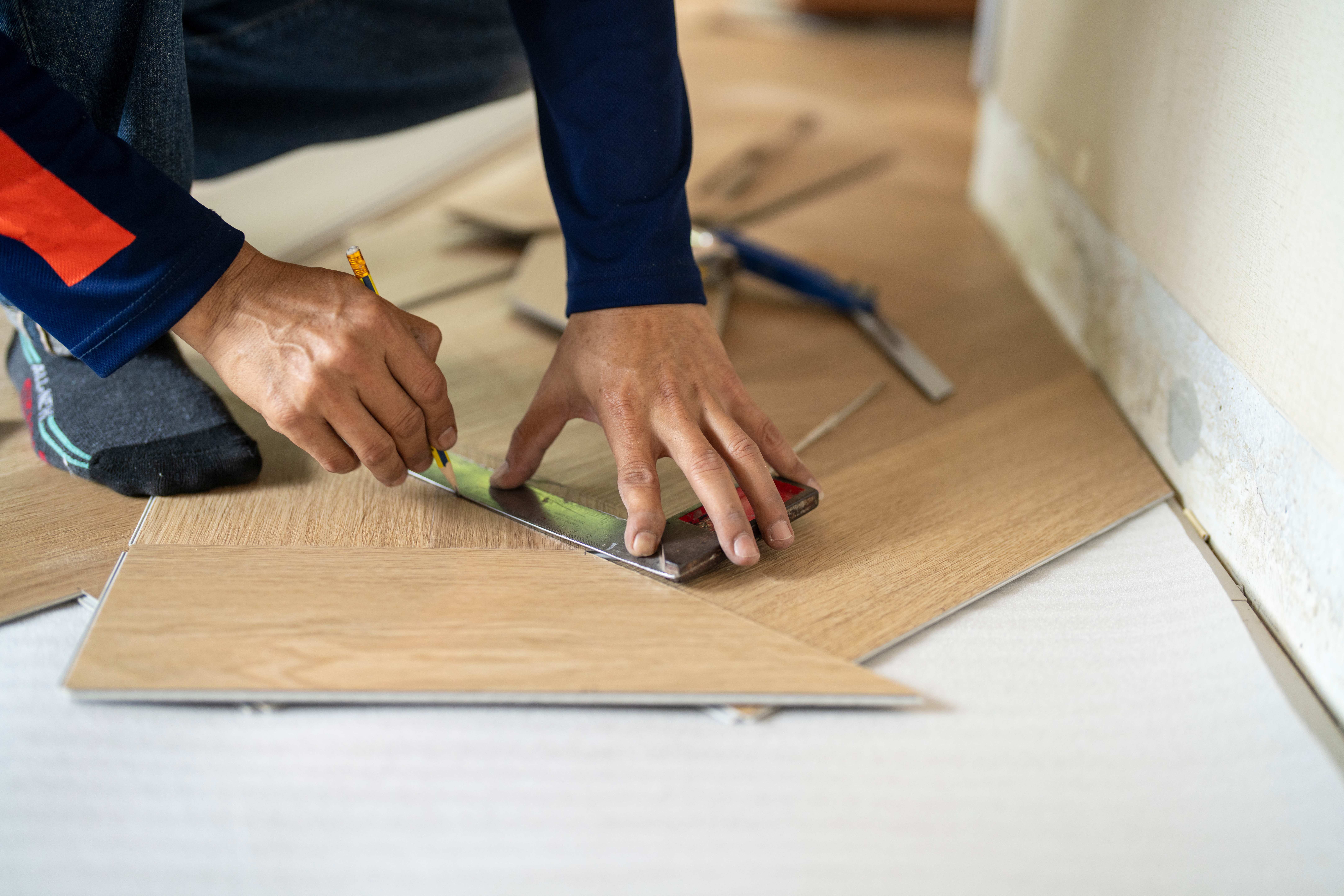 Worker installing wooden laminate flooring