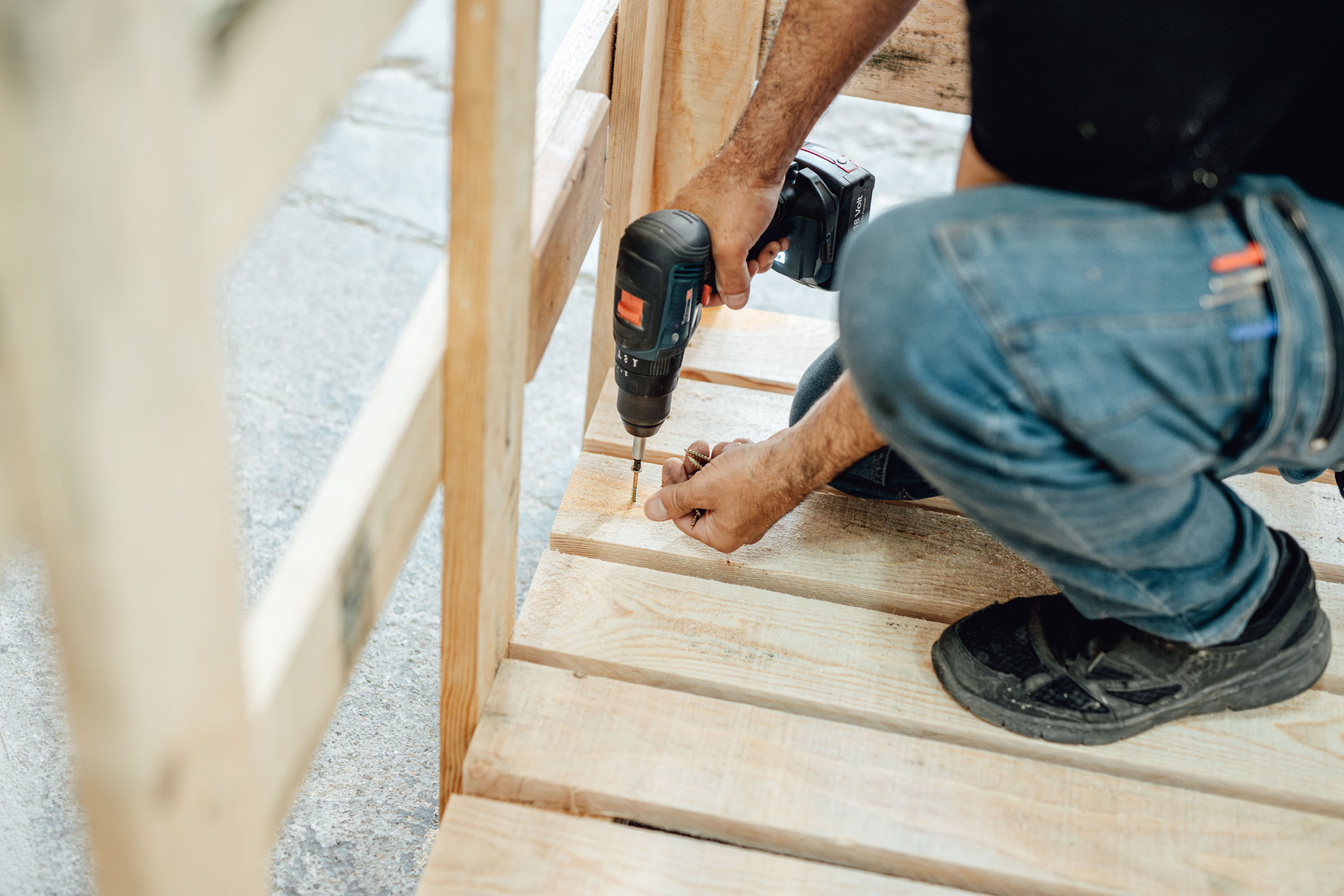 A professional securing wooden boards on deck