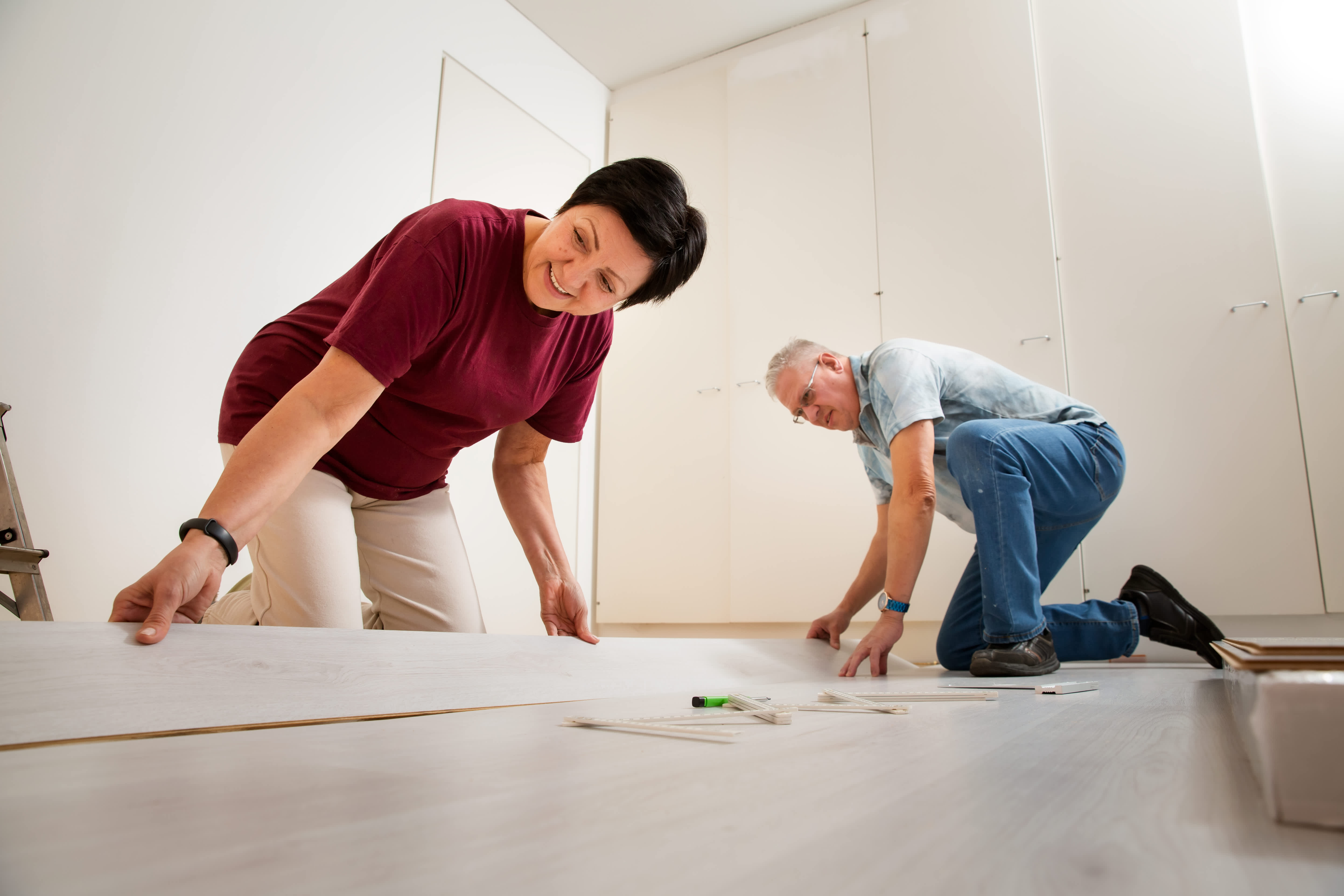 Couple installing laminate flooring in their new home together