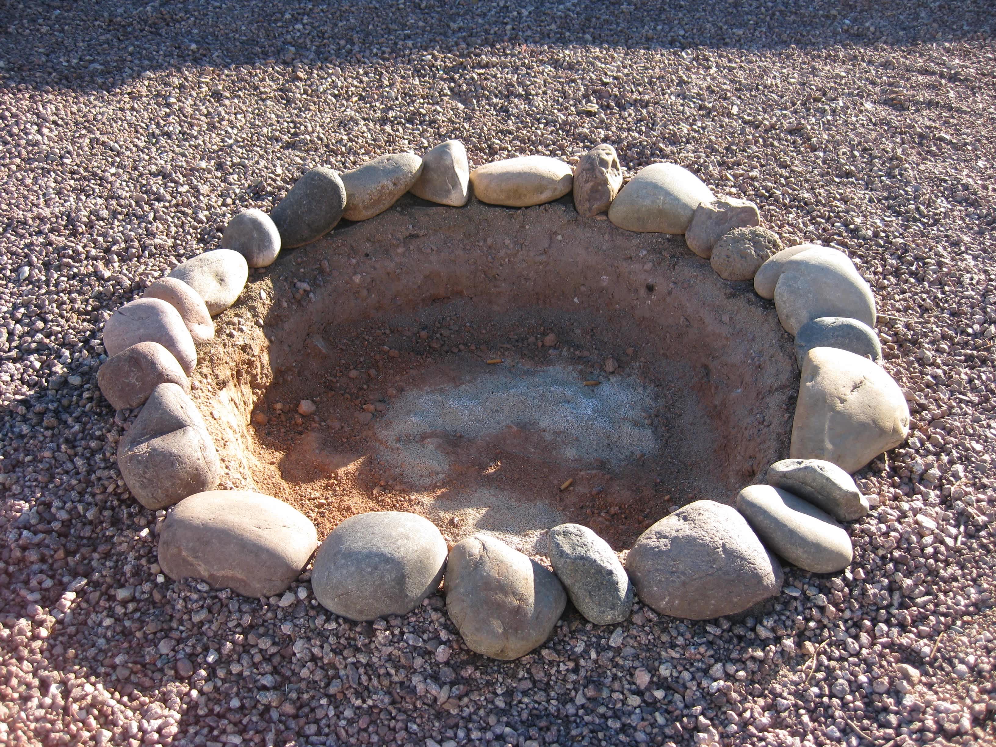 Empty fire pit surrounded by gravel