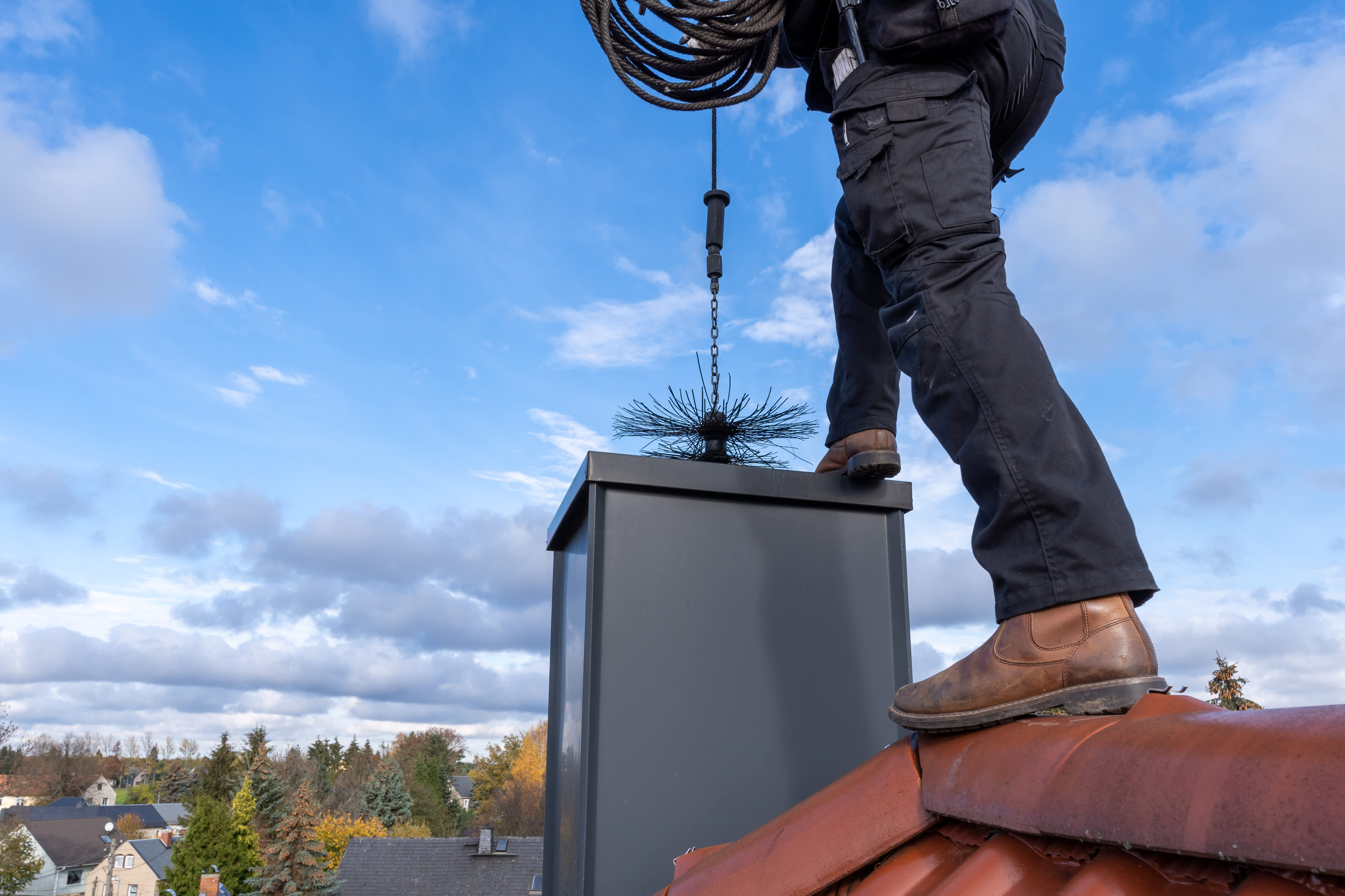 A professional sweeping a chimney