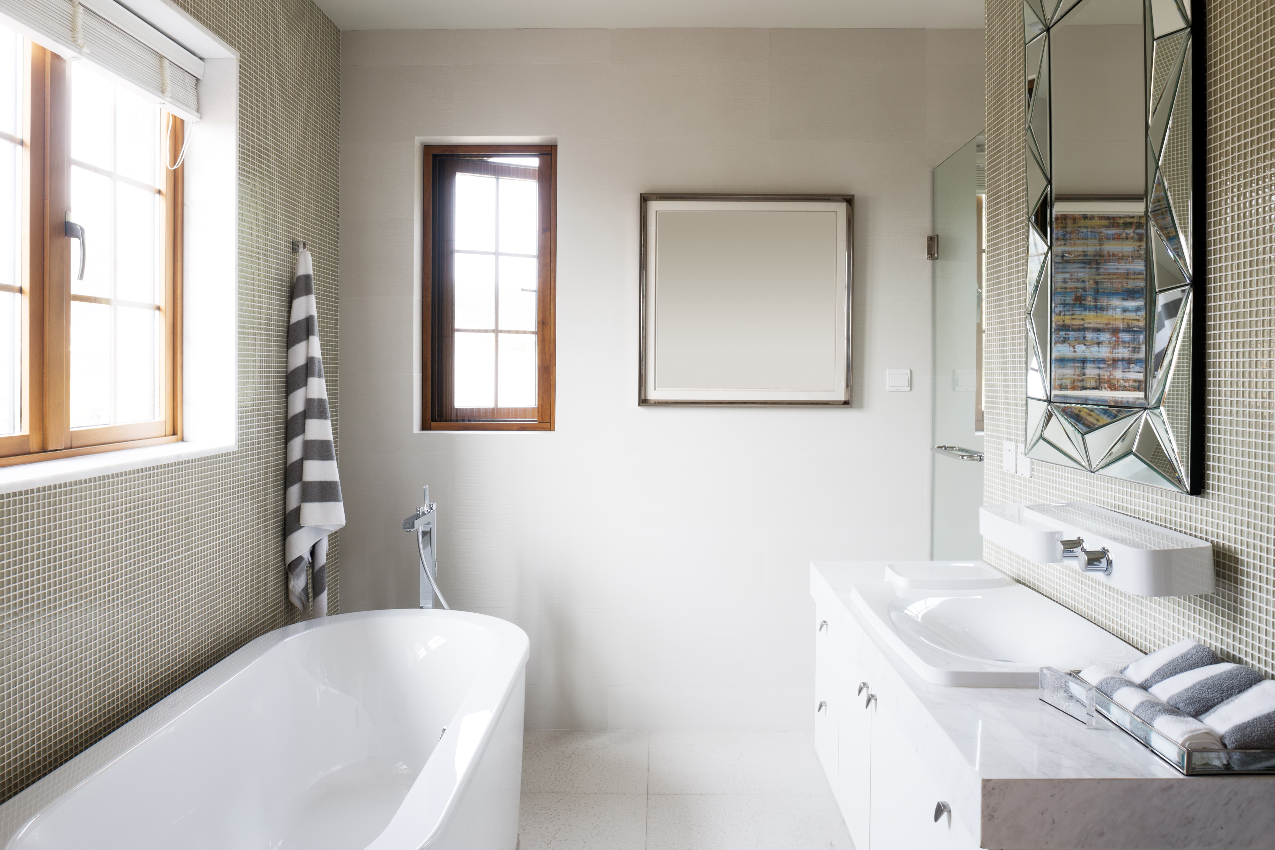 A bright bathroom with a white bathtub