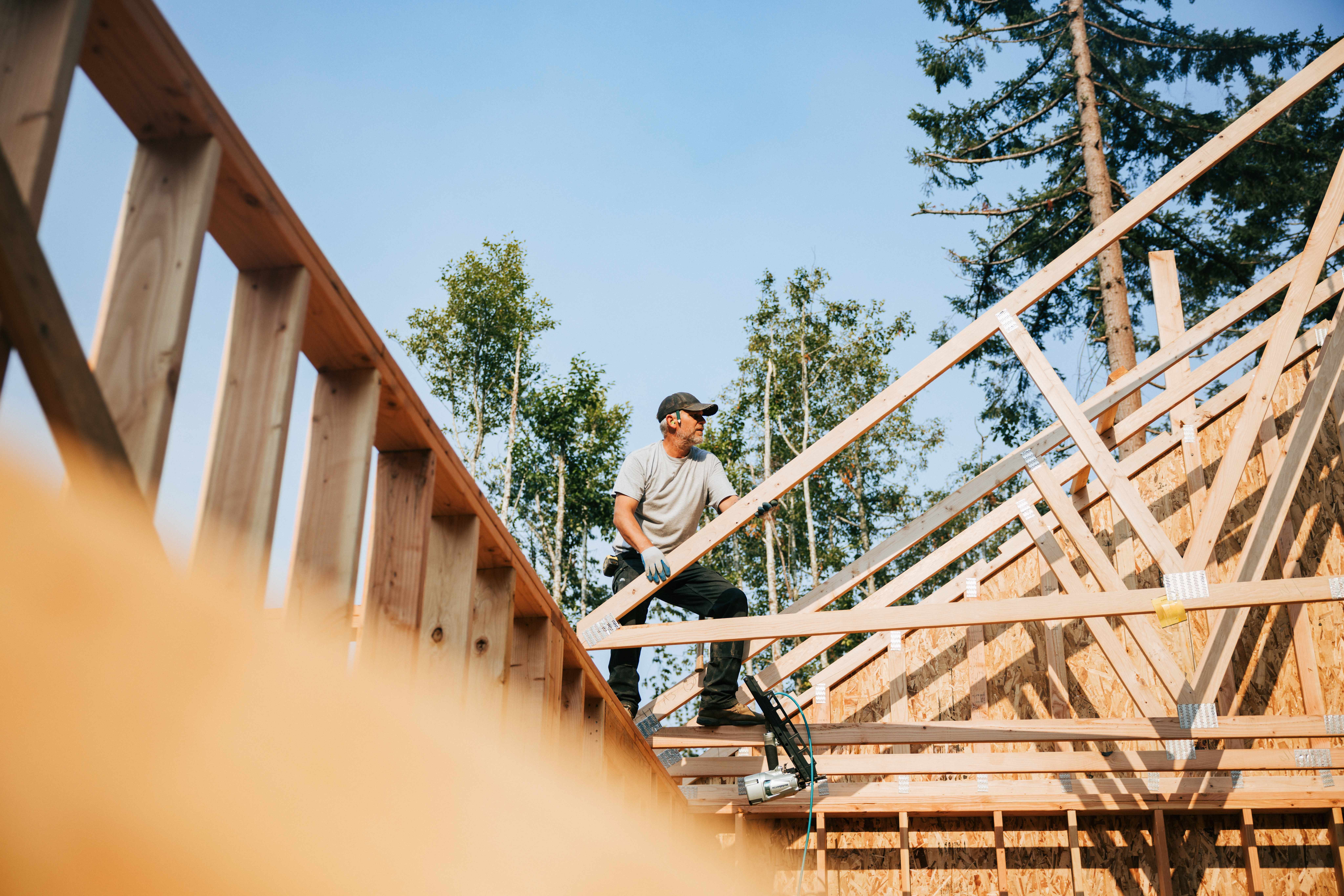 A professional installing trusses on a construction site
