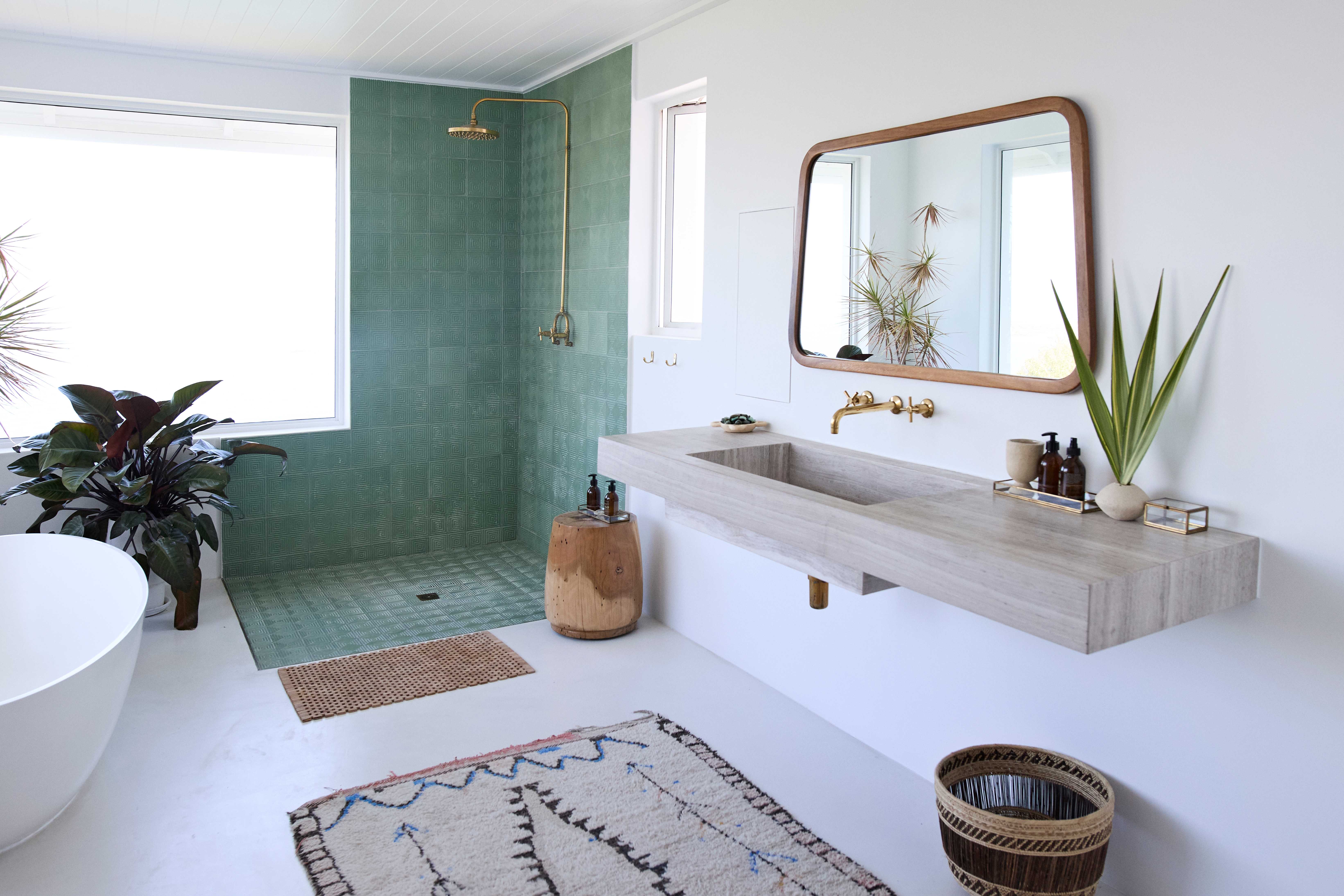 Doorless walk-in shower with green tiles on the floor and walls