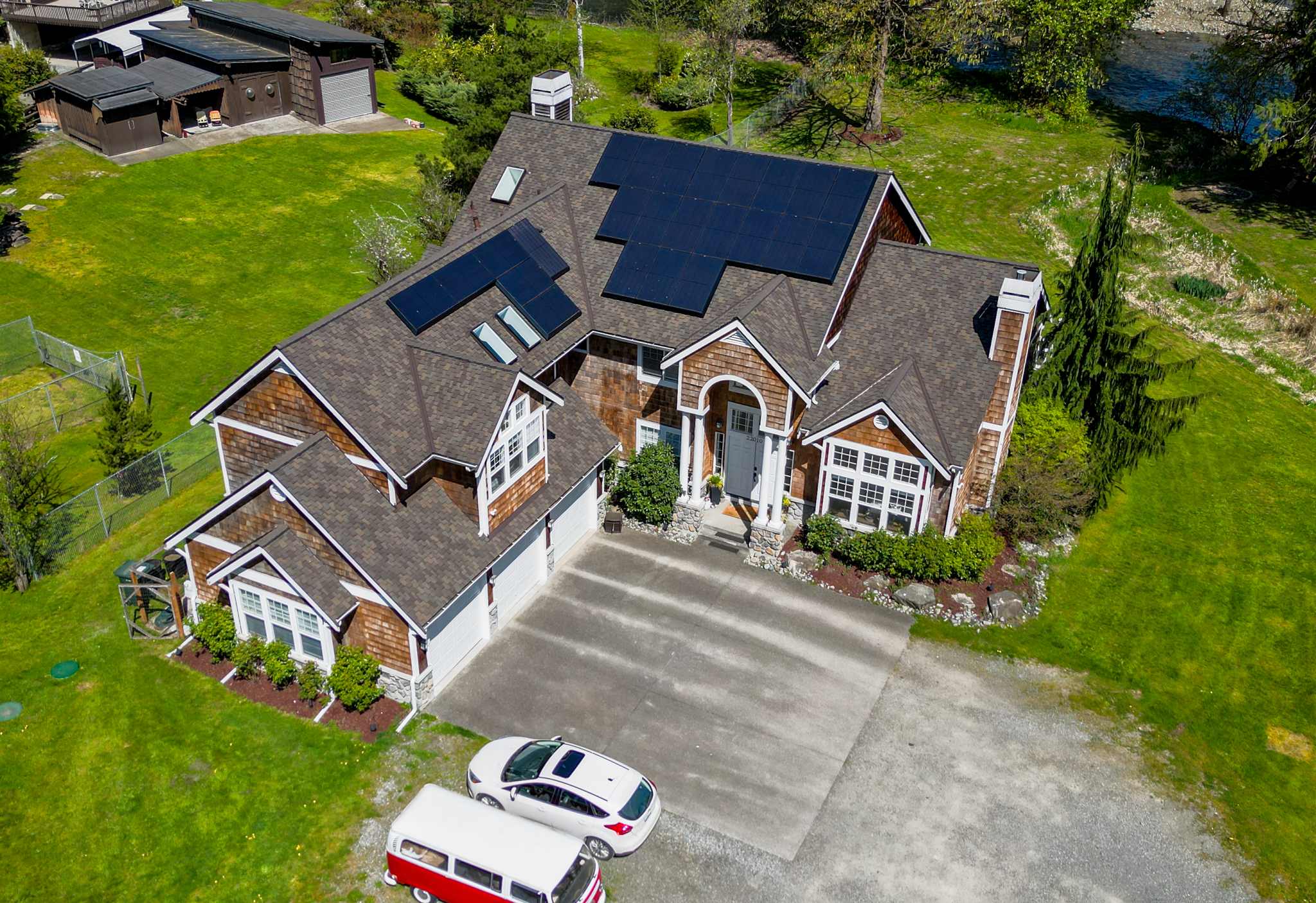Large modern house with brown asphalt shingle roof and solar panels in Kent, WA