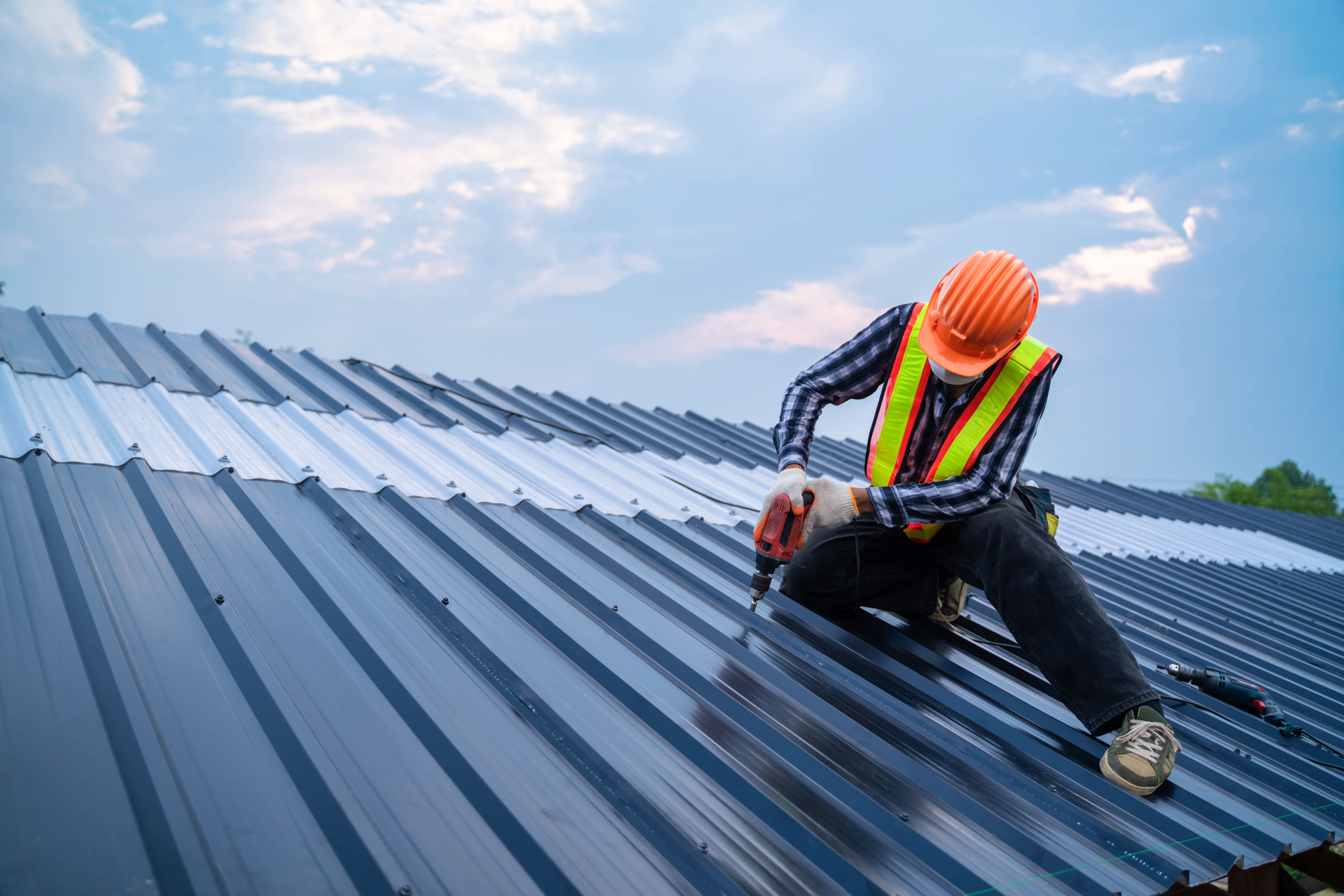 man installing metal roof