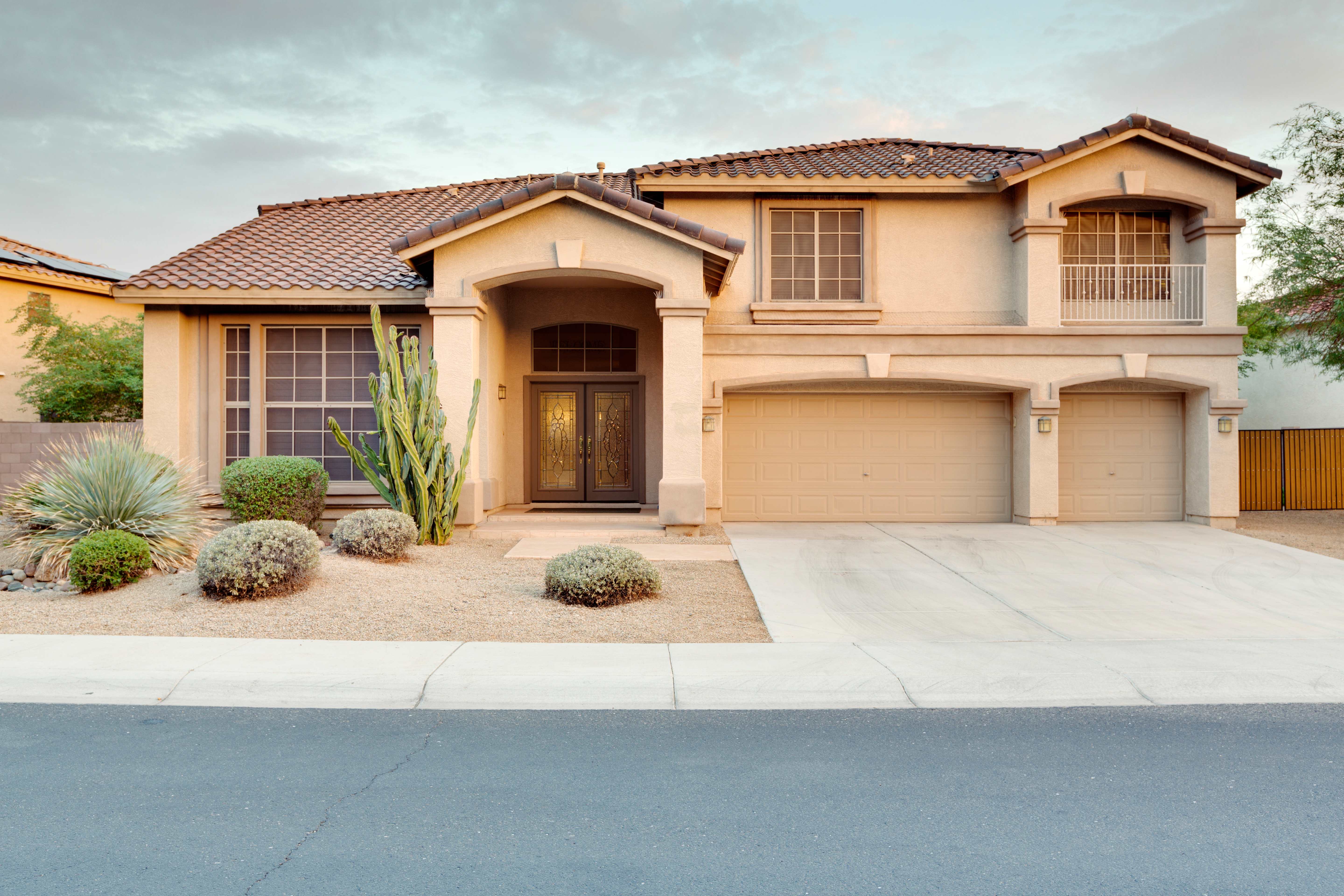 Large home exterior with stucco siding and tile roof