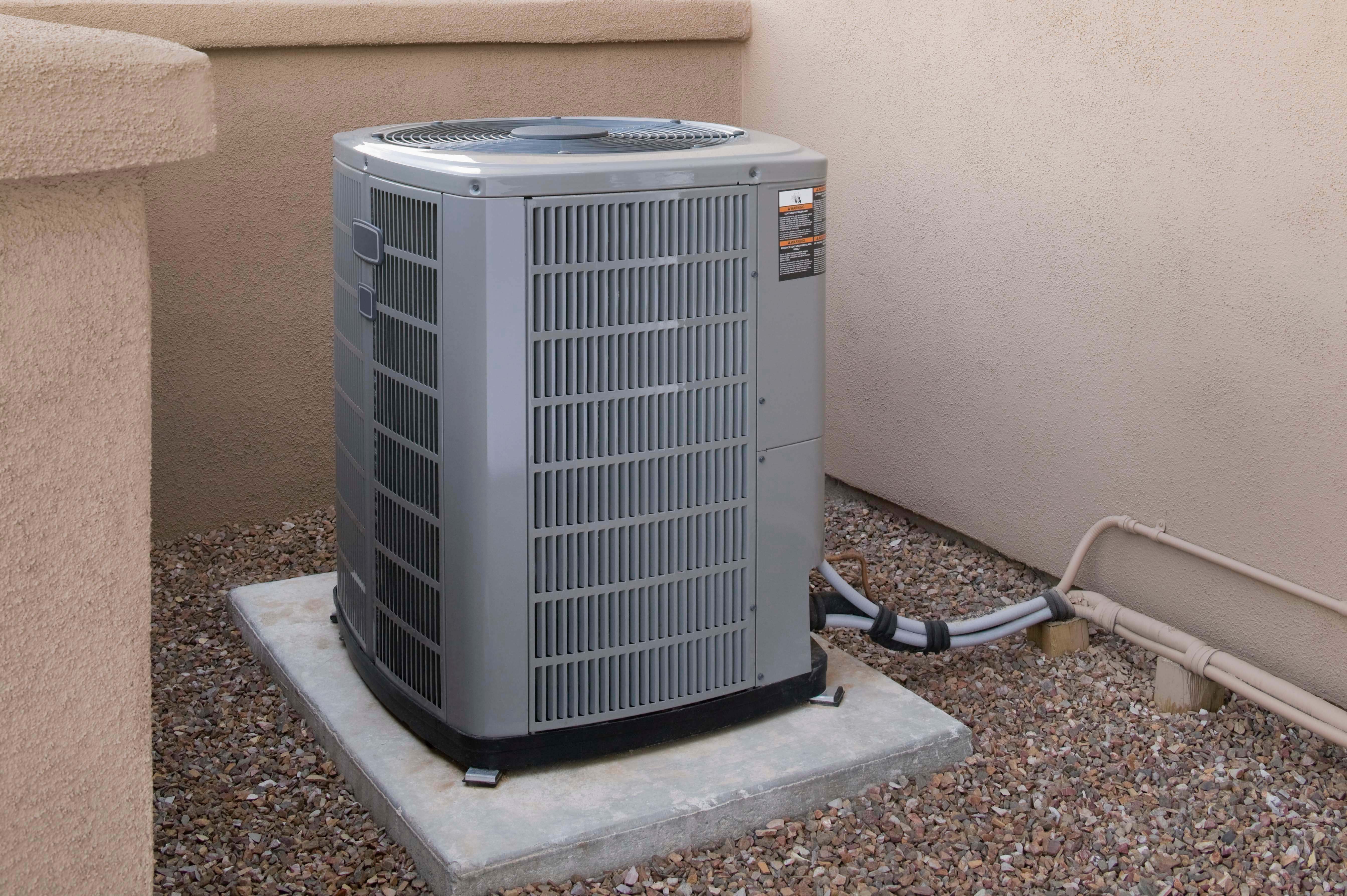 Central AC unit sitting on a concrete slab