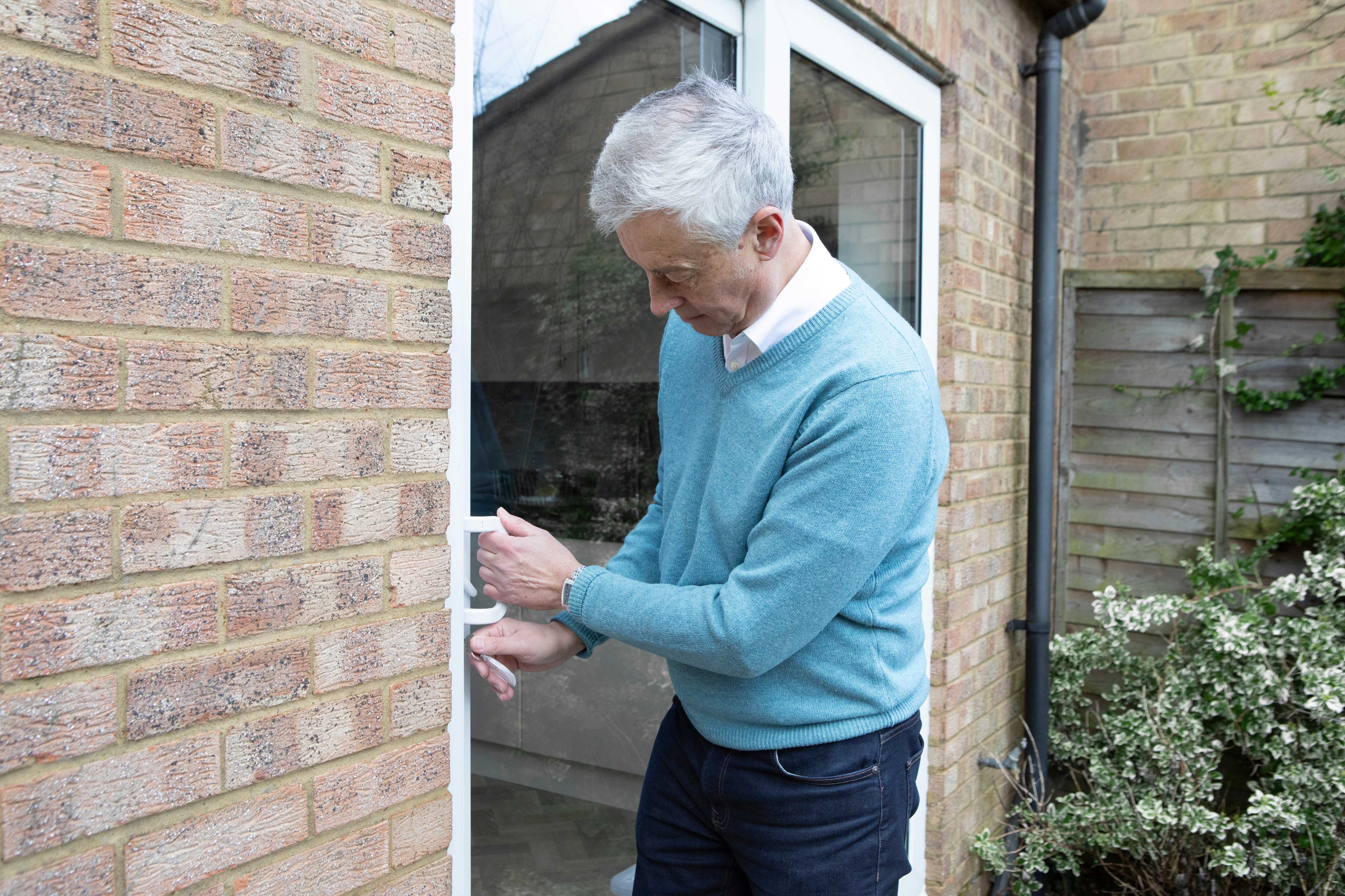 man unlocking a patio door