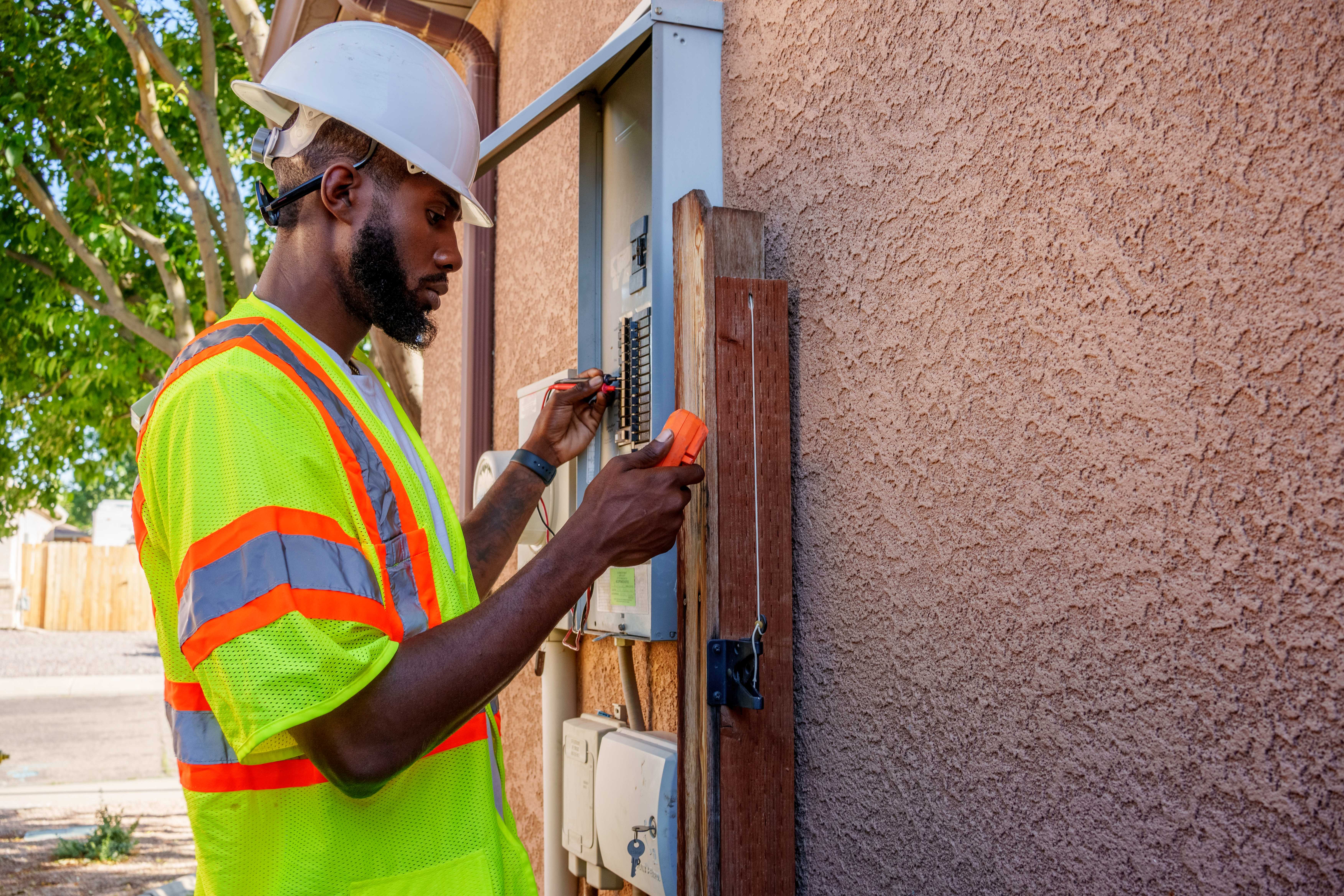 Worker checking outdoor electrical panel