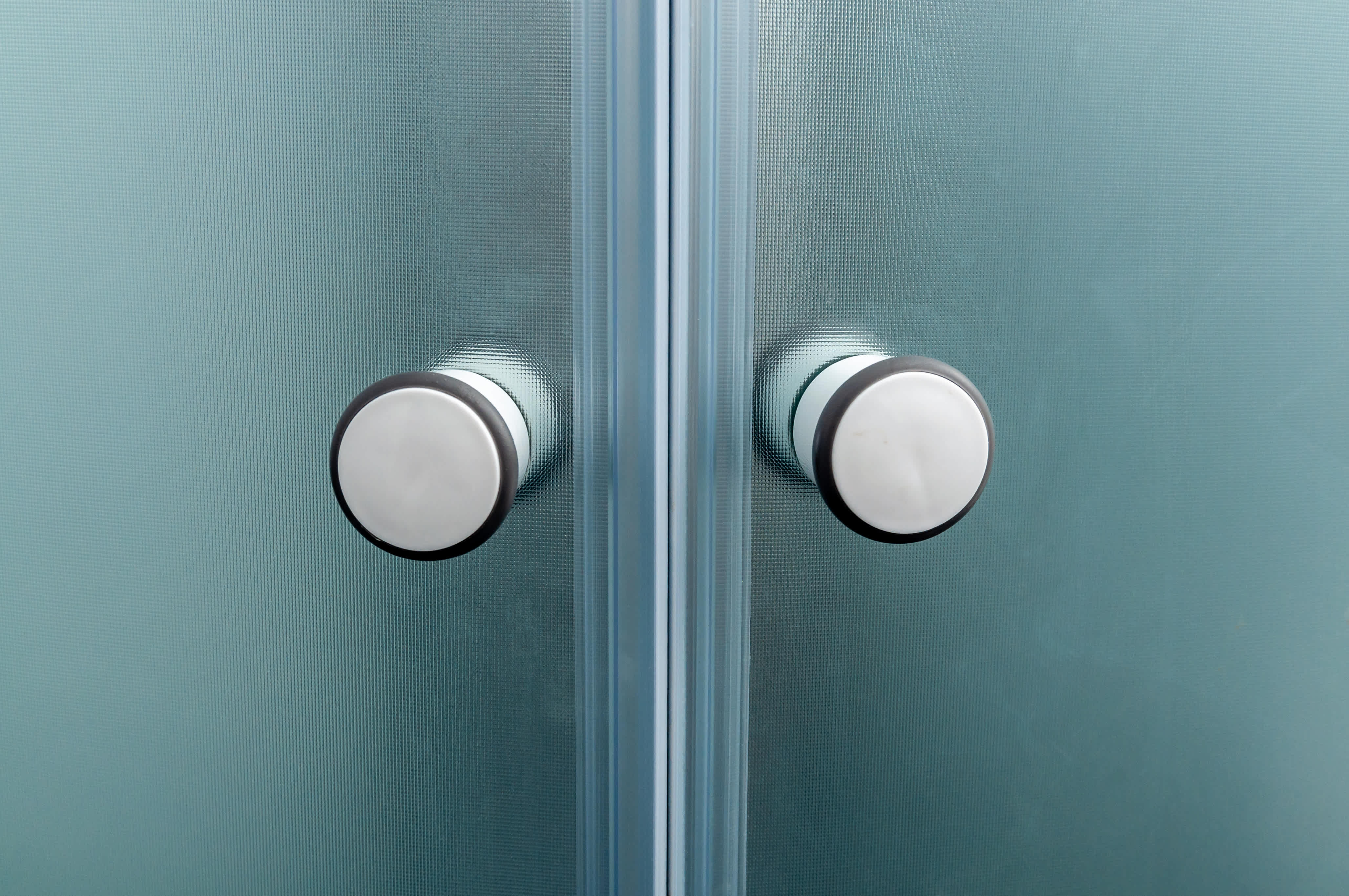 Close up of shower door knobs.