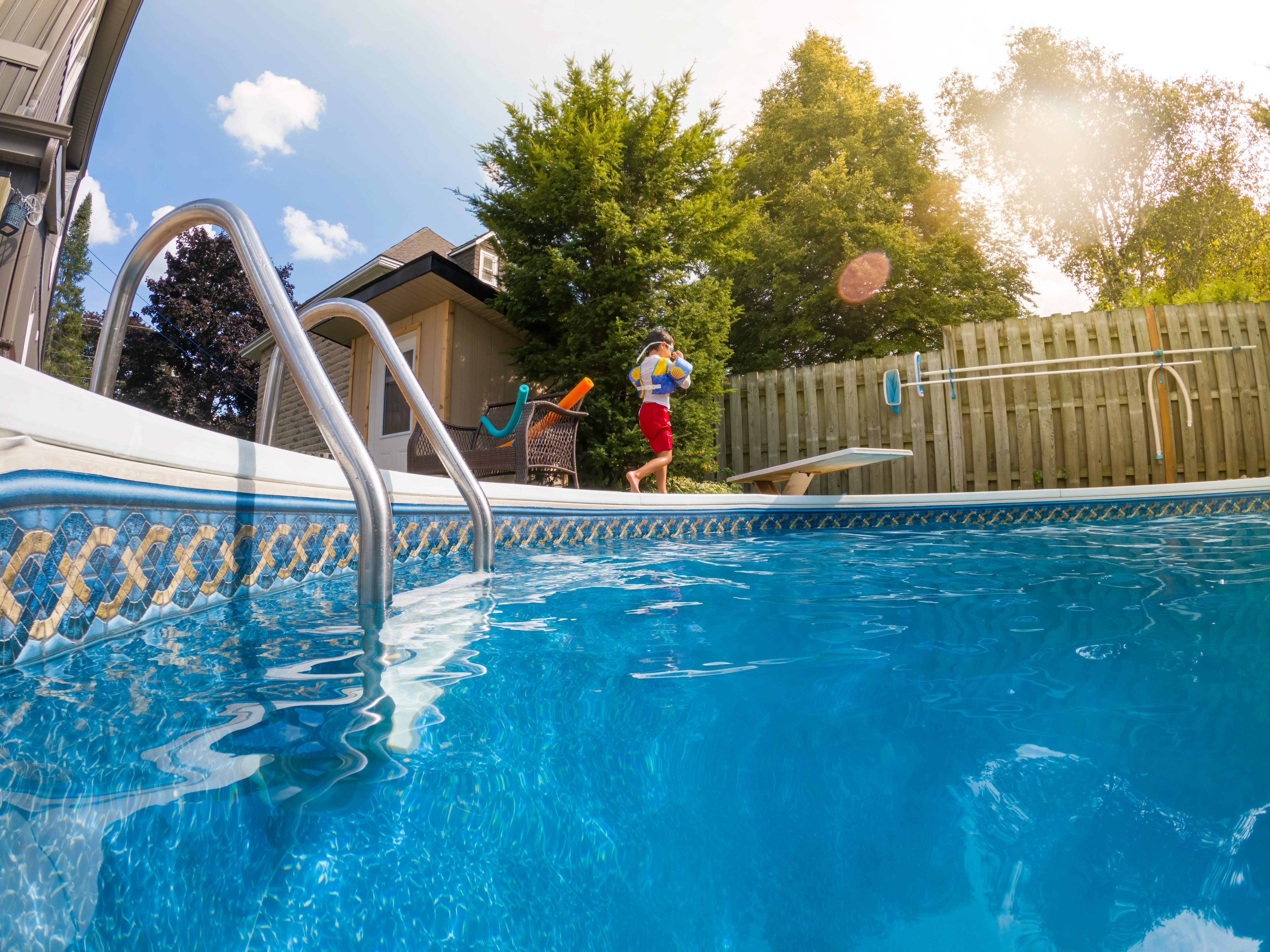 boy walking beside swimming pool