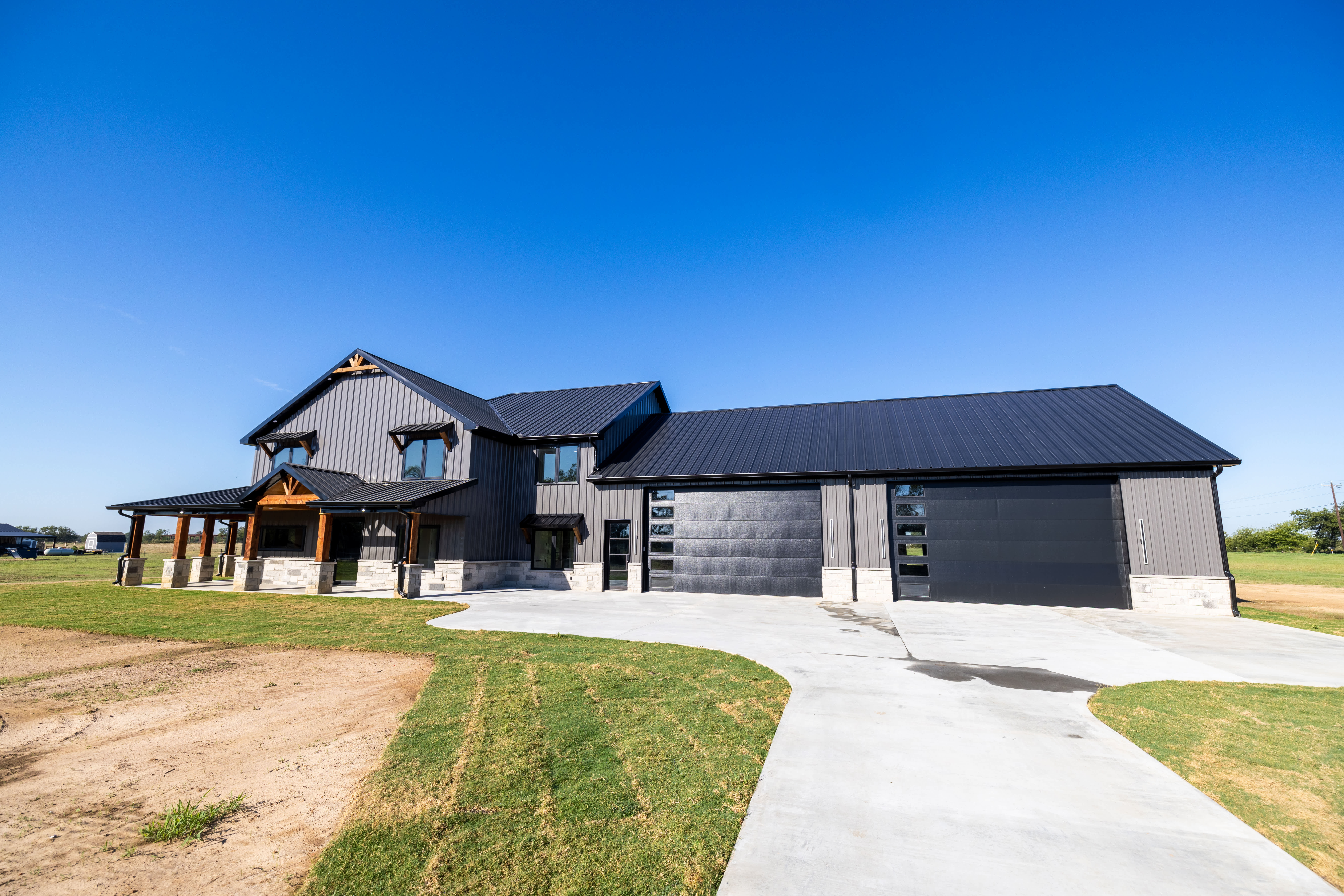 large barndominum home with black metal roof