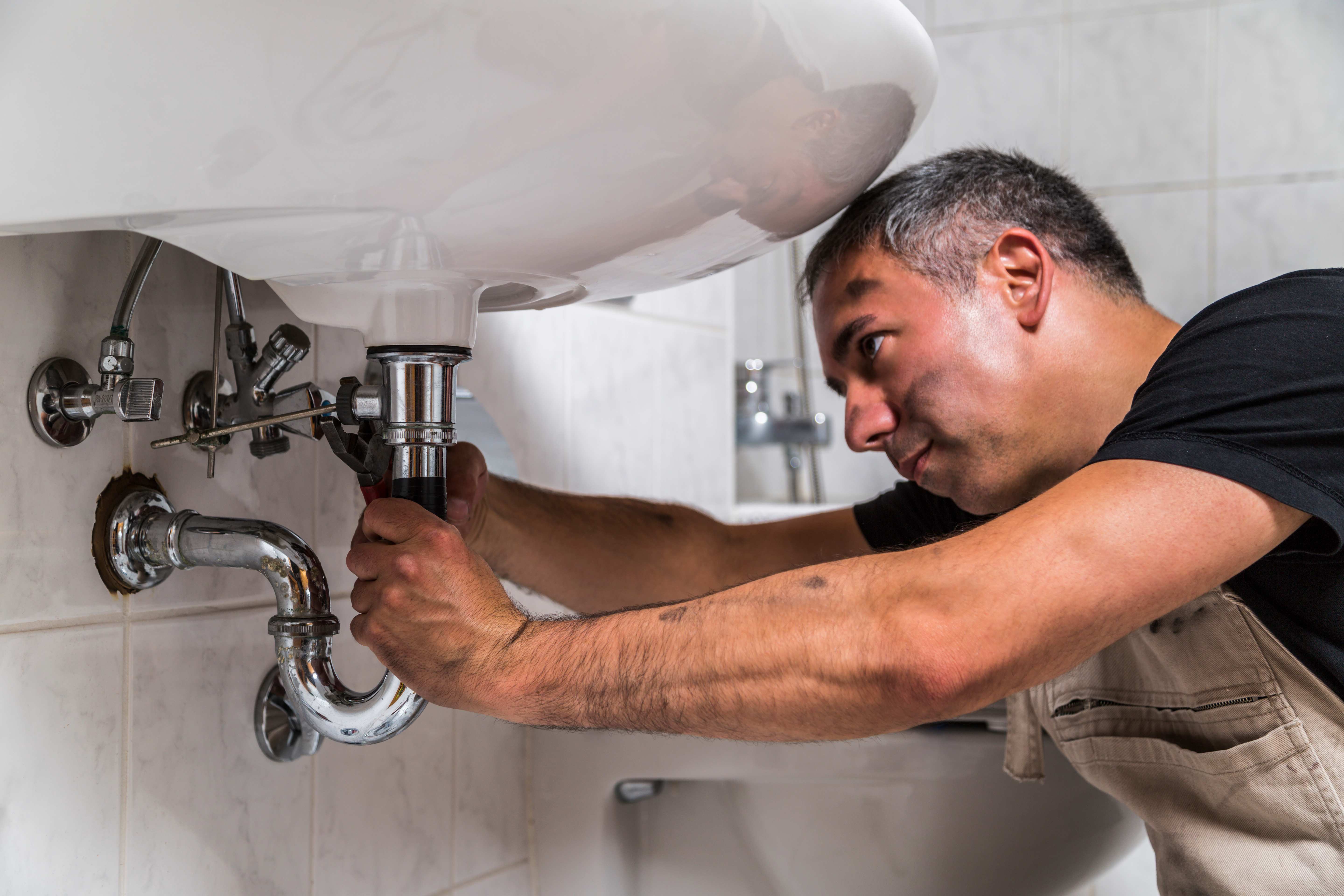 plumber fixing bathroom sink
