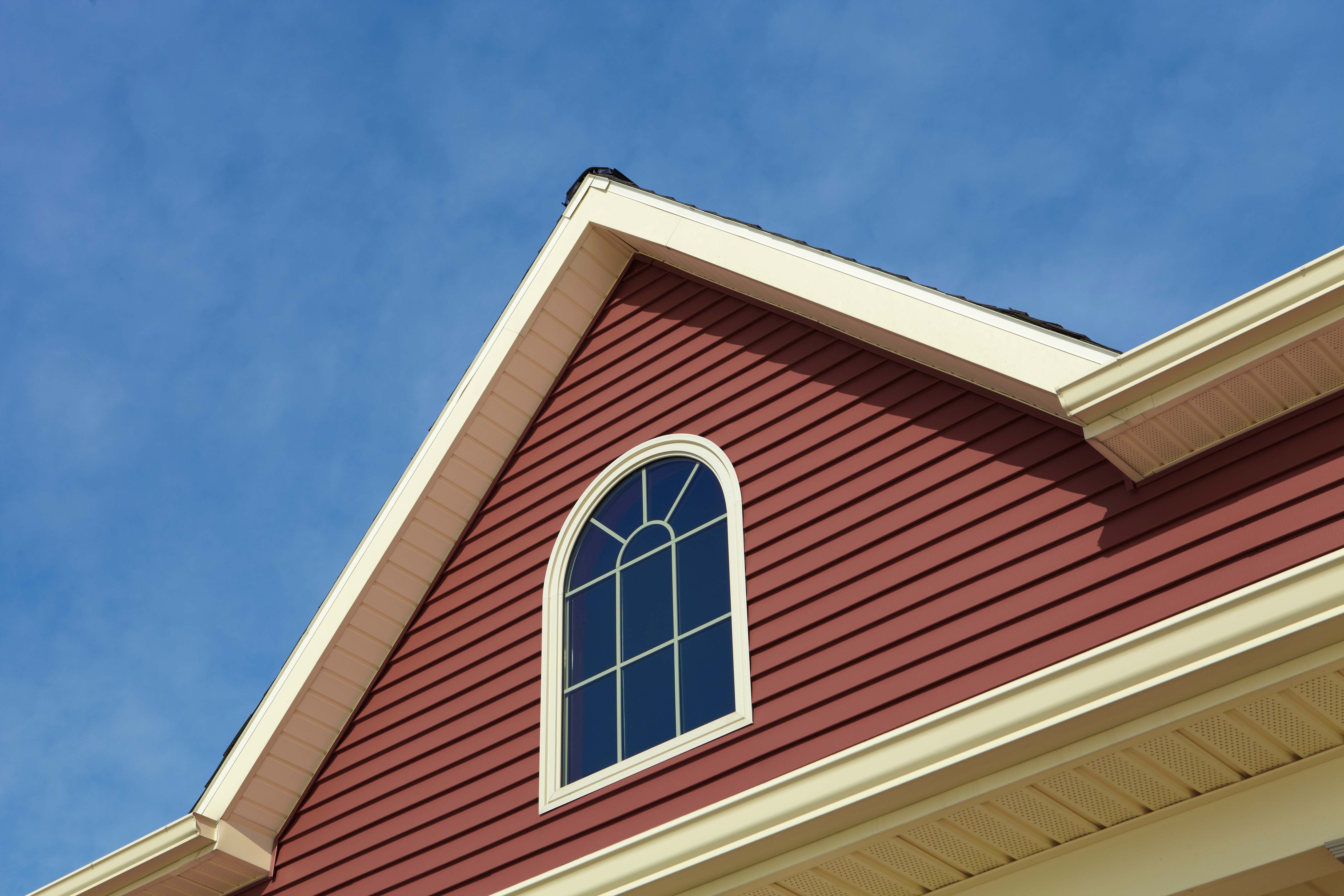 A house with siding against the blue sky